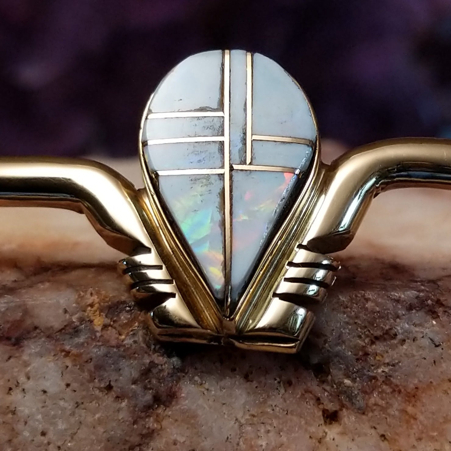 Close up of teardrop opal inlay with geometric 14kt gold channels.