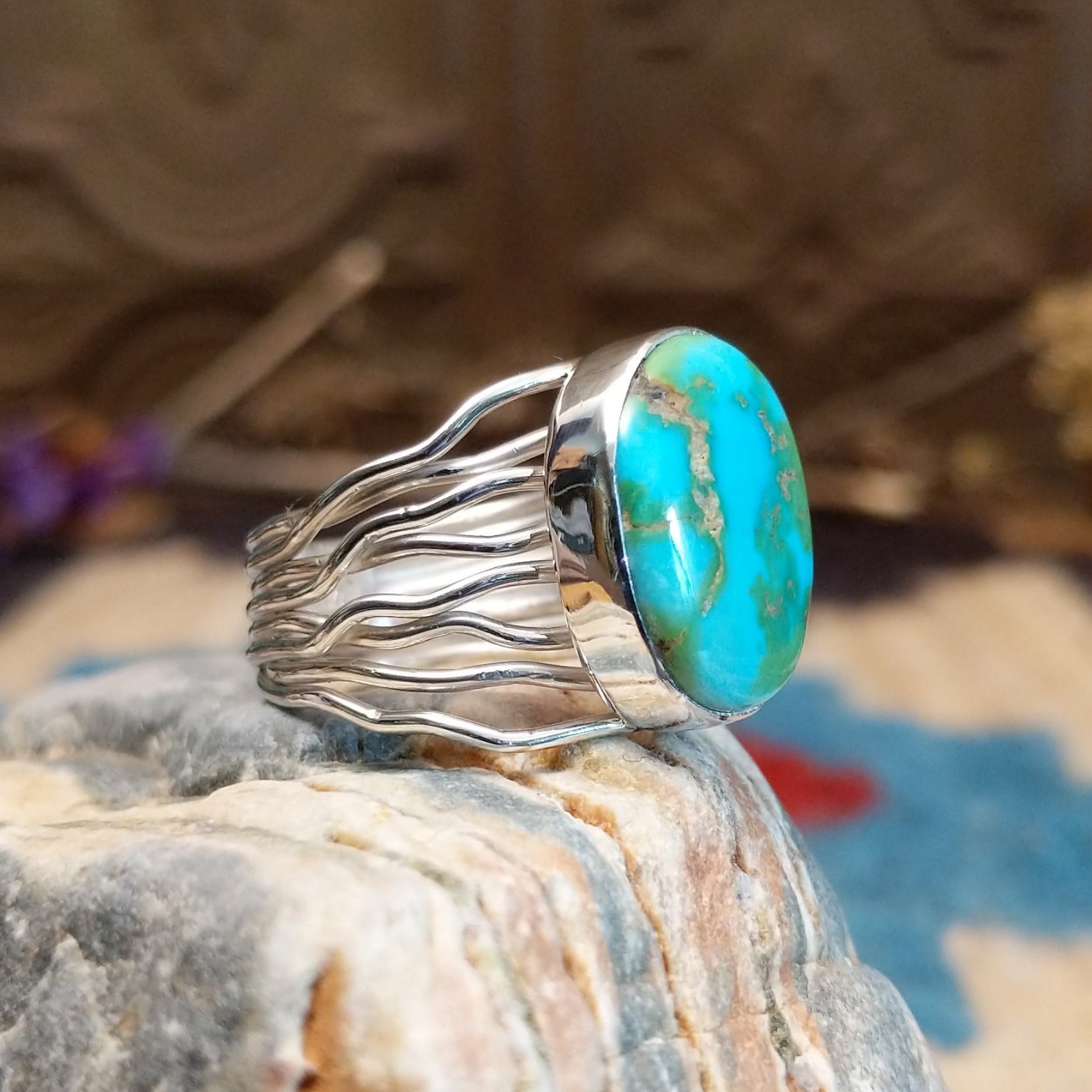 Sterling silver ring with Sonoran gold turquoise set in an oval bezel and band with strands of silver.