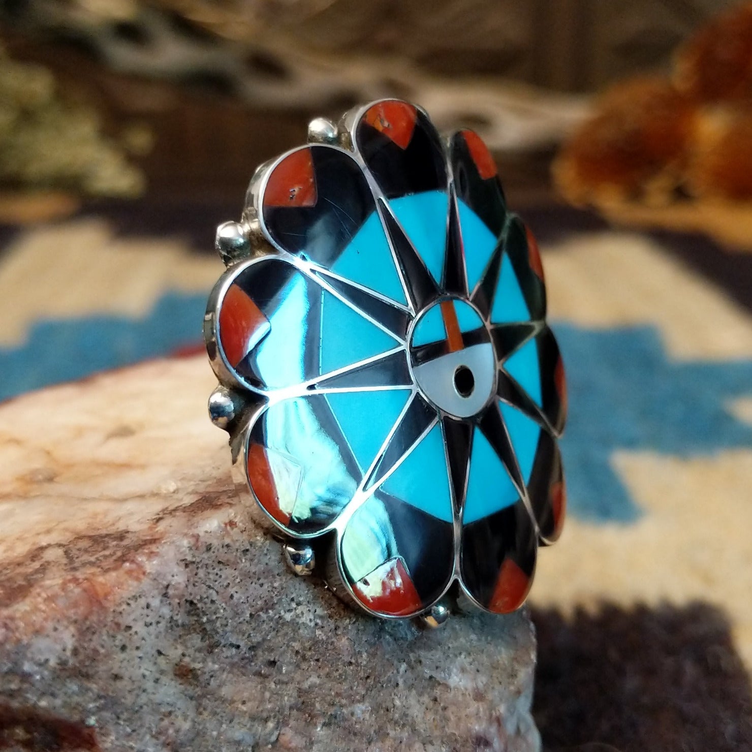 Sterling silver ring with multistone inlay creating a sunface motif.