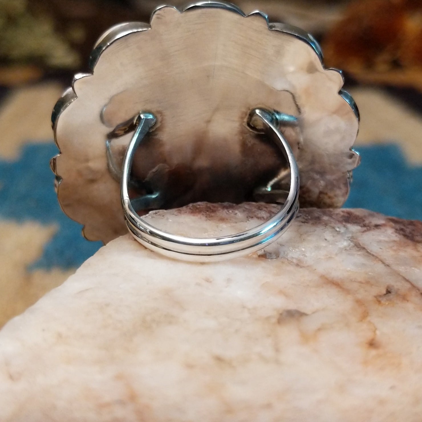 Sterling silver ring with multistone inlay creating a sunface motif.