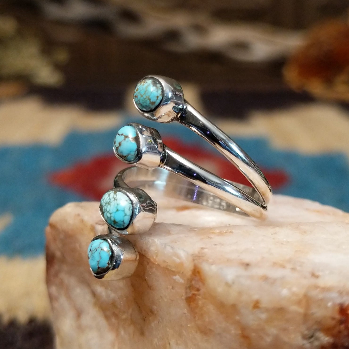 Sterling silver ring with #8 turquoise set in individual, round bezels suspended on strands of silver.