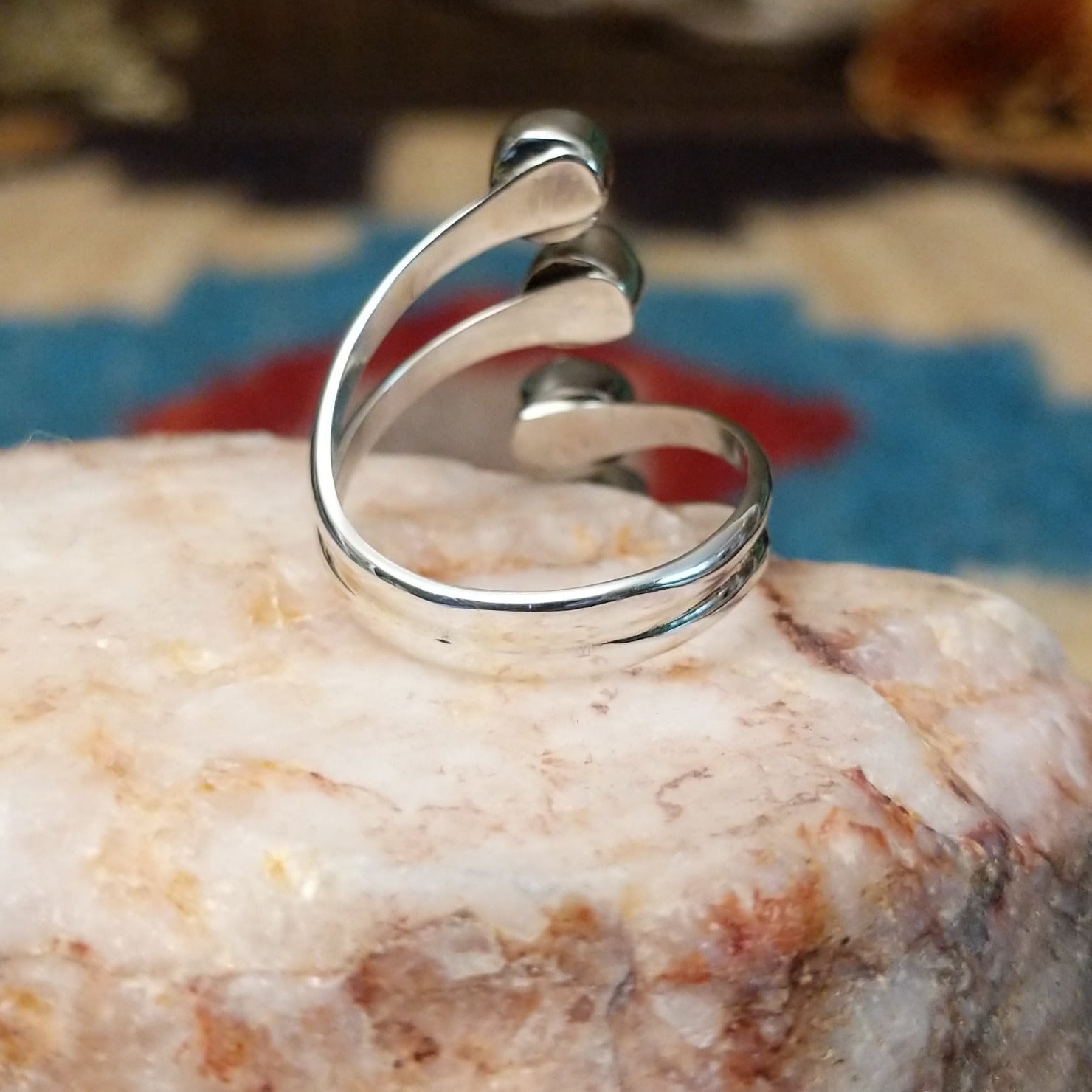 Sterling silver ring with #8 turquoise set in individual, round bezels suspended on strands of silver.