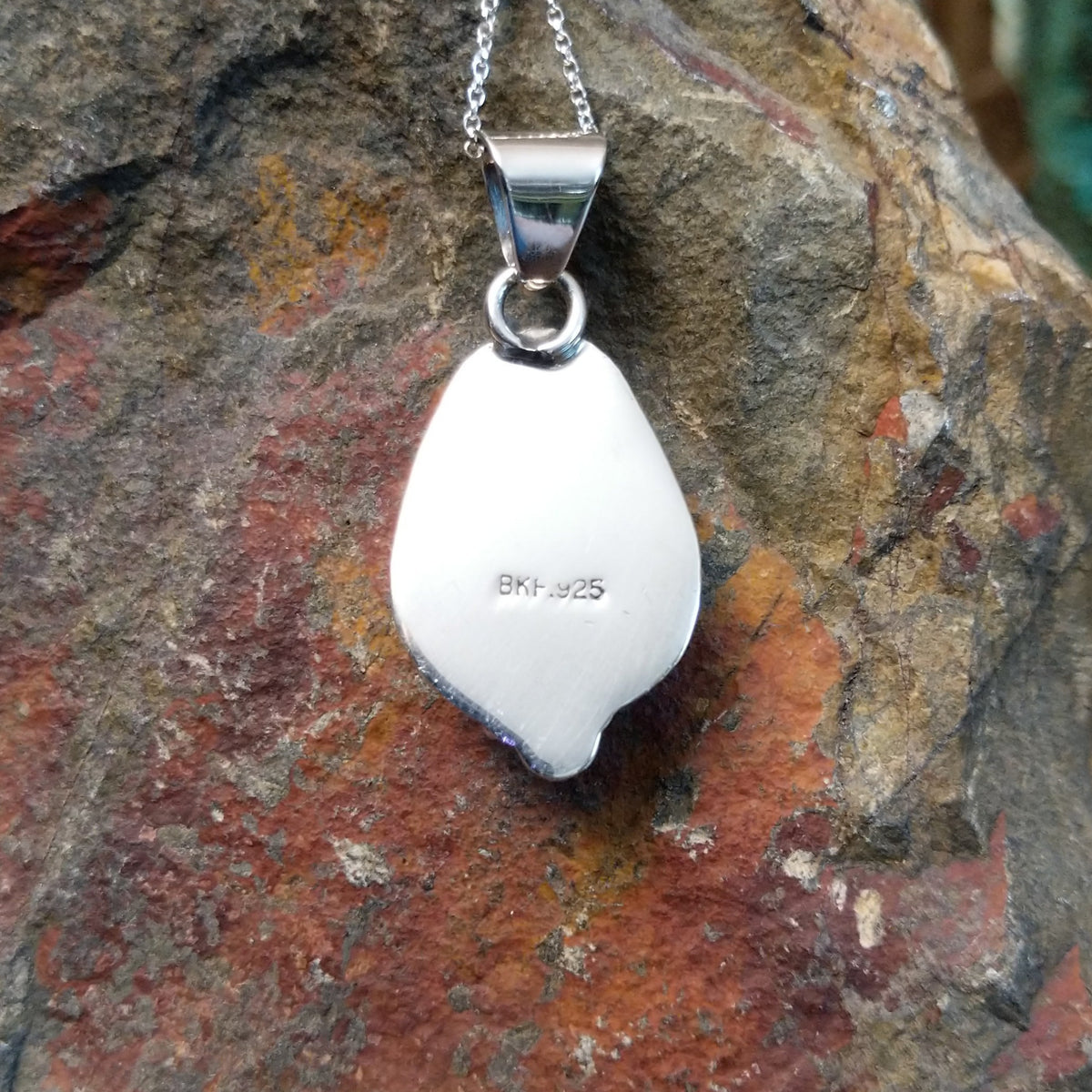 #8 turquoise pendant by Burt Francisco featuring a large teardrop-shaped blue turquoise stone with brown and golden matrix framed in twisted sterling silver; artisan and .925 (Sterling Silver) stamp.