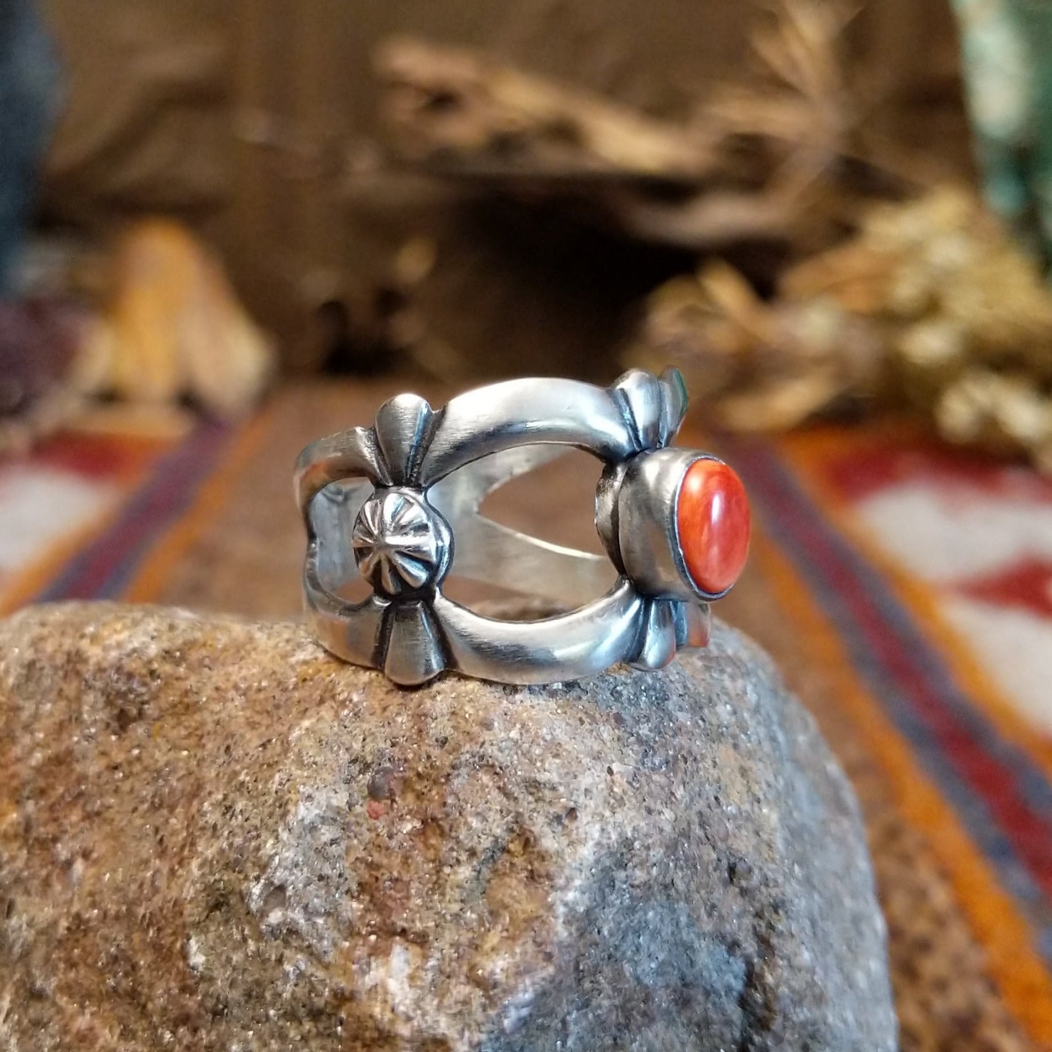 Sterling silver ring with coral centerpiece set in the bezel and open concept design of the band.
