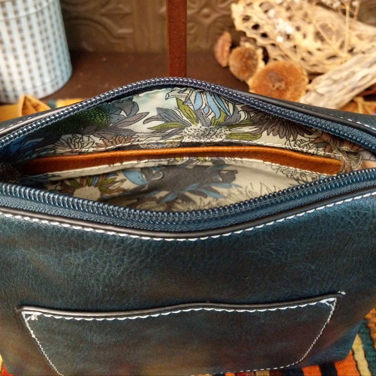 Alexa Handbag by Liz Soto featuring a tall structured silhouette, decorative contrast stitching, vertical center detailing, large wrapped circular accent, and wide shoulder strap; interior.