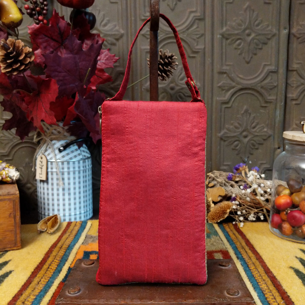 Americana Club Bag by Bamboo Trading featuring a sparkling American flag design with red and cream beaded stripes, gold stars on a textured blue background, and a coordinating red shoulder strap; back side view.
