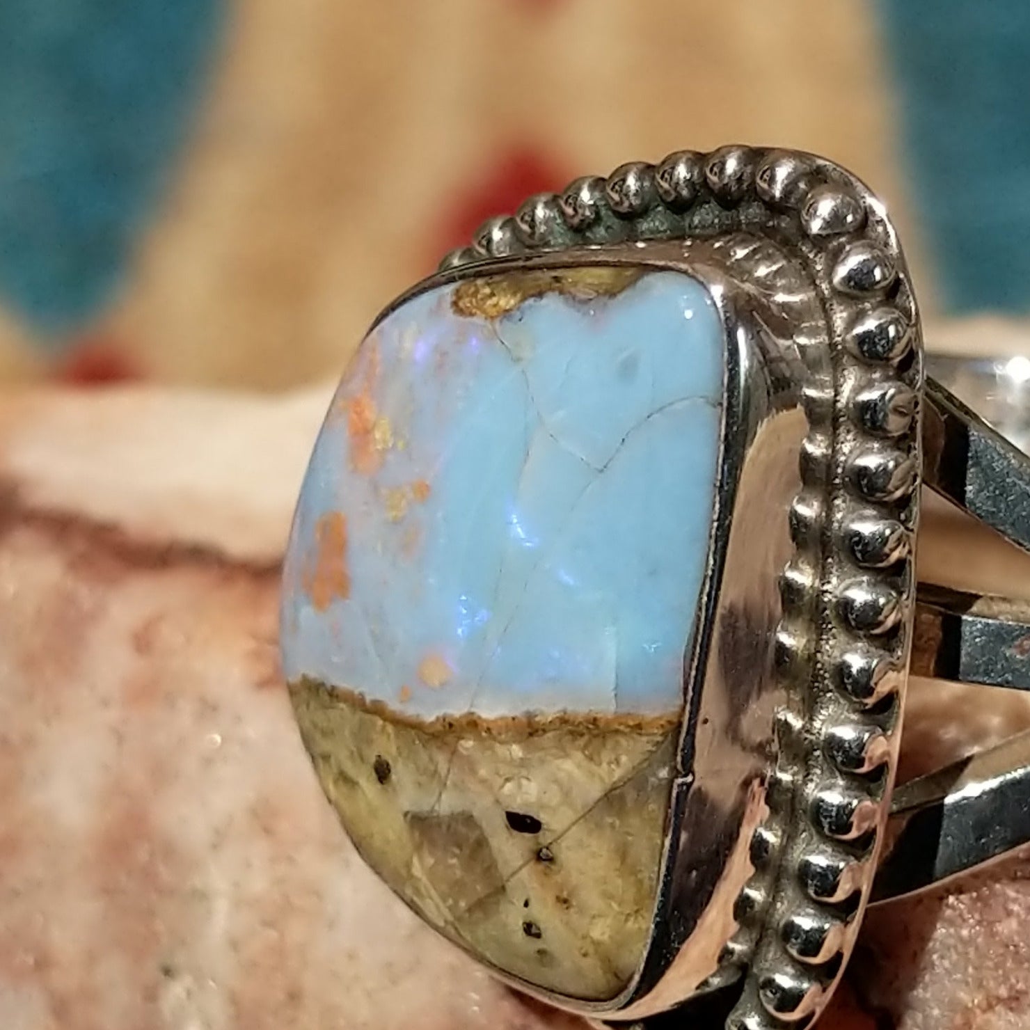 Sterling silver ring with Arizona blue opal set in the bezel, framed by dotted accents.