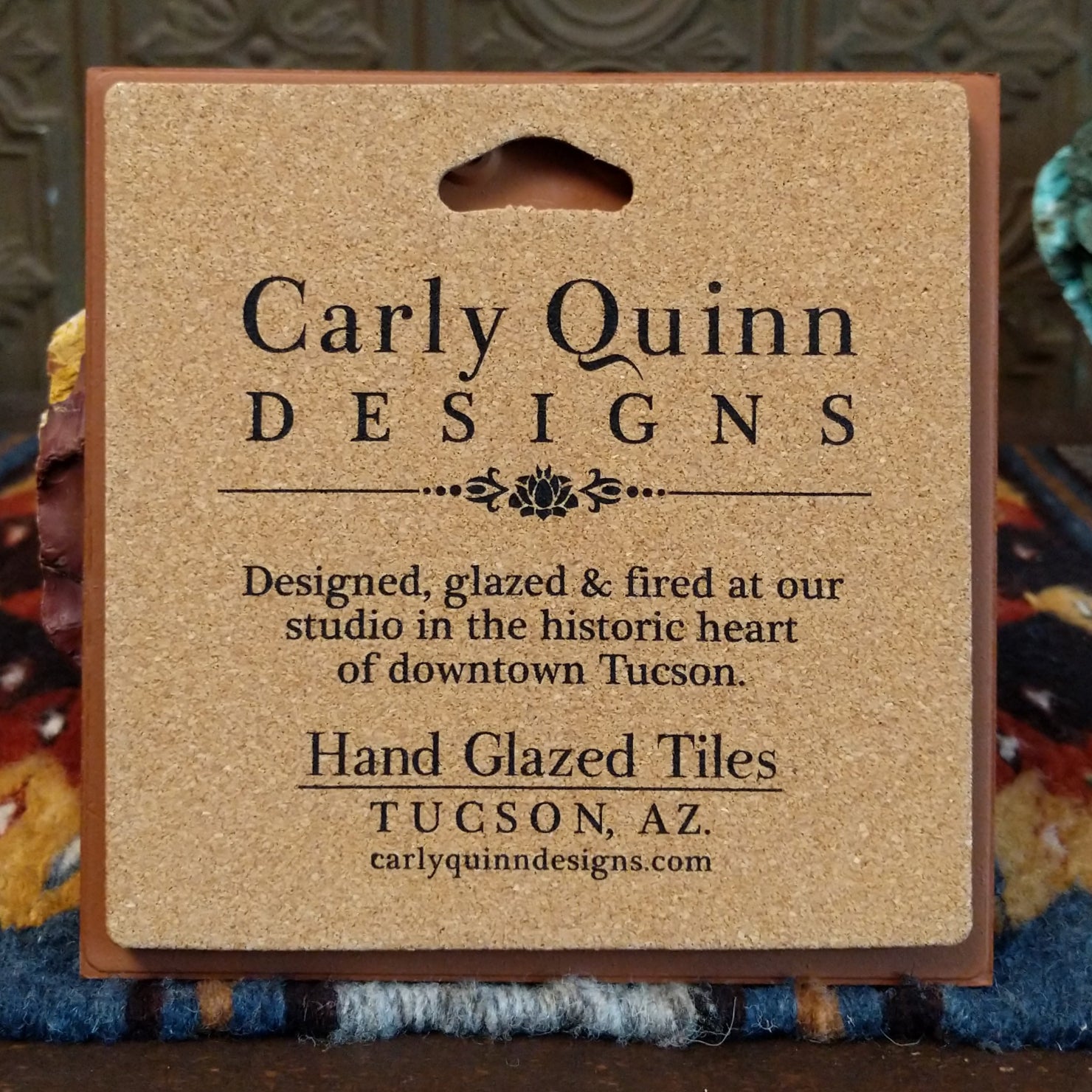 Corkboard backing of a hand-glazed ceramic tile with artist details.