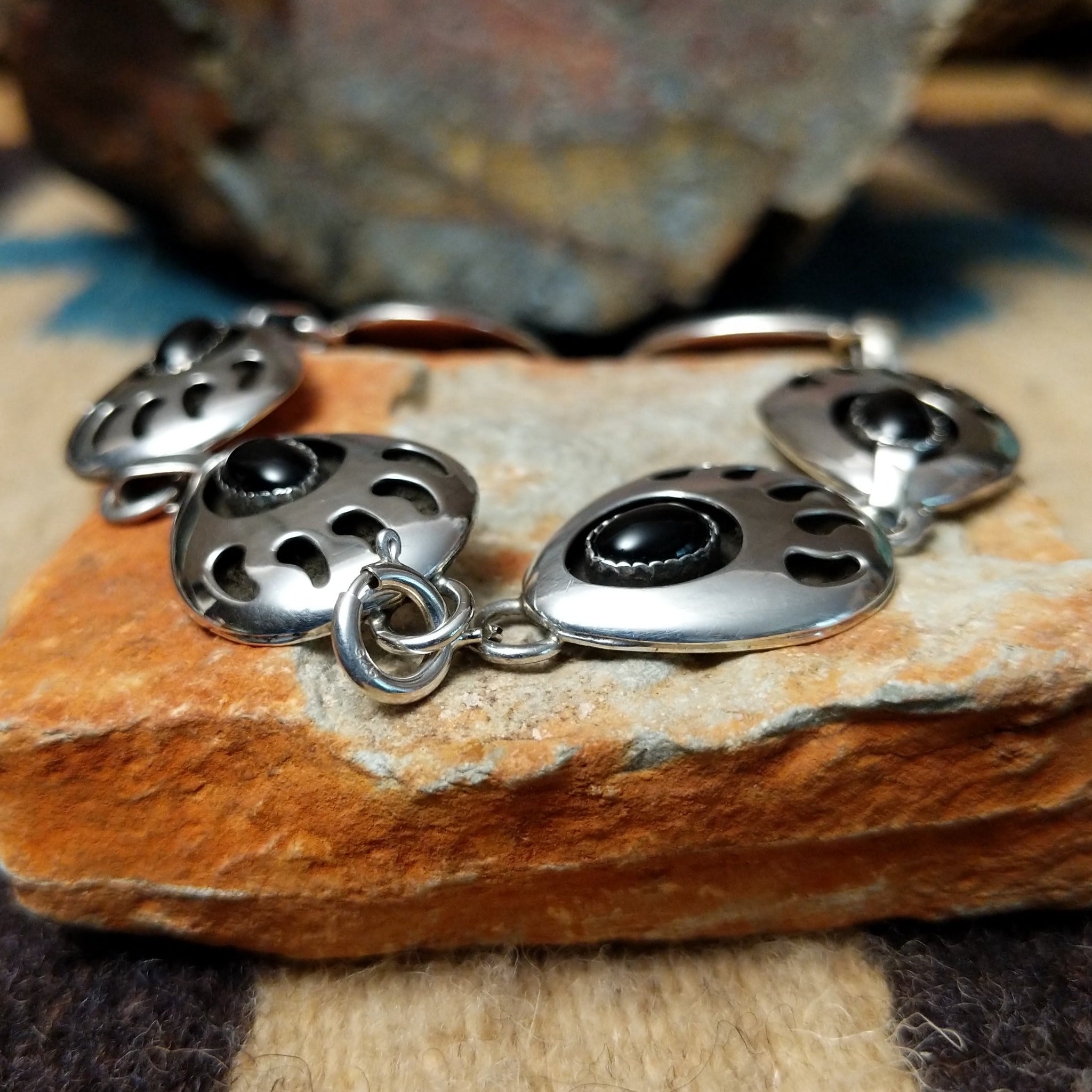 Sterling silver bear paw shadowbox bracelet by George Jones with a black onyx stone and hand-stamped Southwestern details; clasp view.