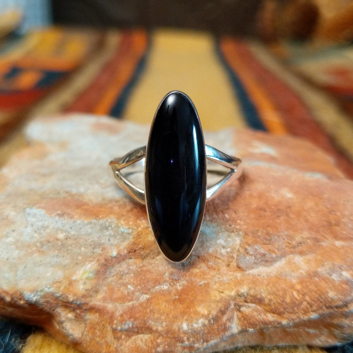 Black Onyx Ring by Cathy Webster featuring an elongated oval polished black onyx stone set in sterling silver with a smooth bezel and open split-shank band.