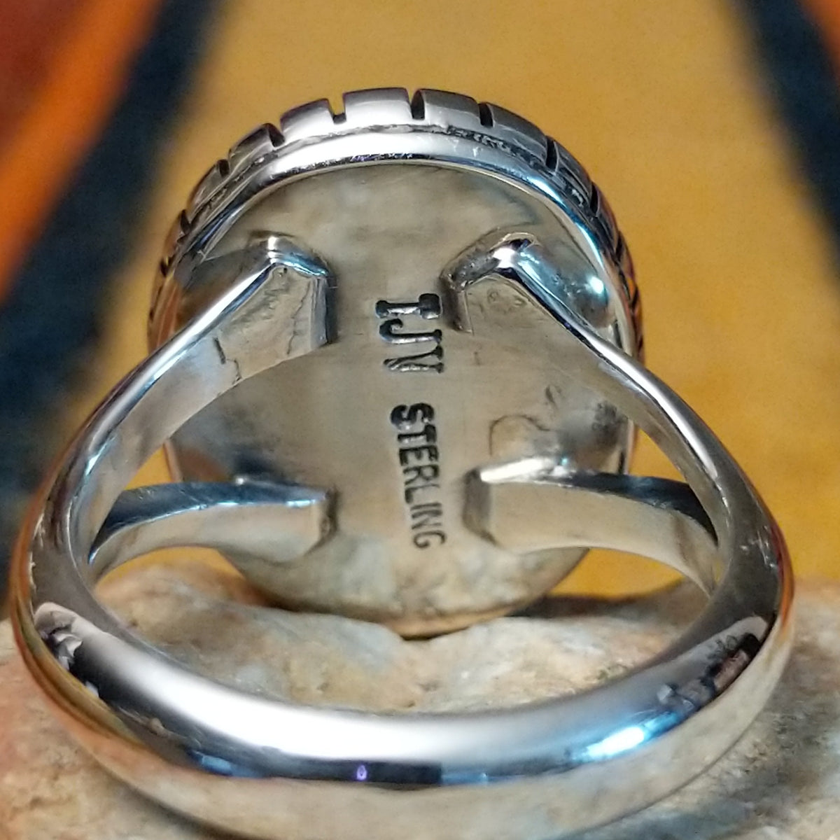 Rear view of a silver black onyx ring showing the open split-shank construction and the Artisan's stamped signature.