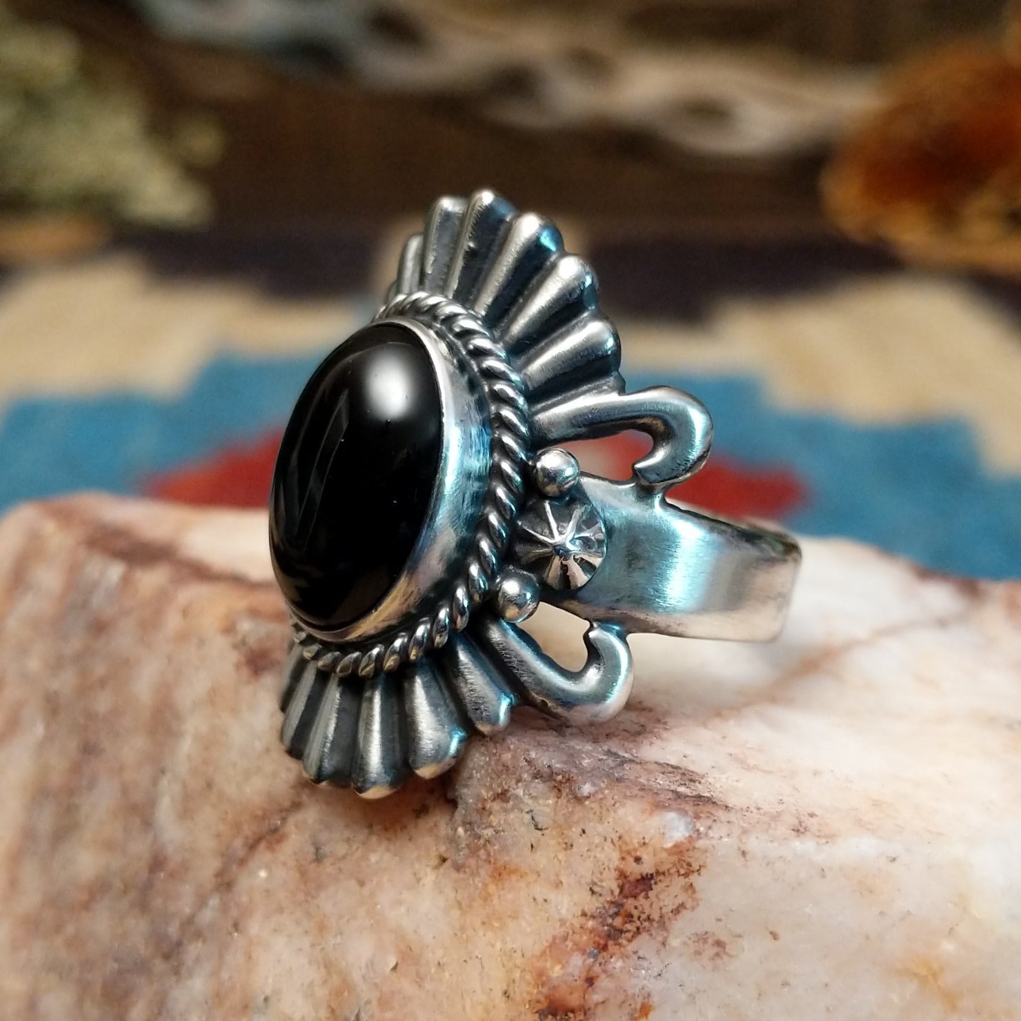 Sterling silver ring with black onyx set in the bezel, framed by twisted rope and unique silverwork.