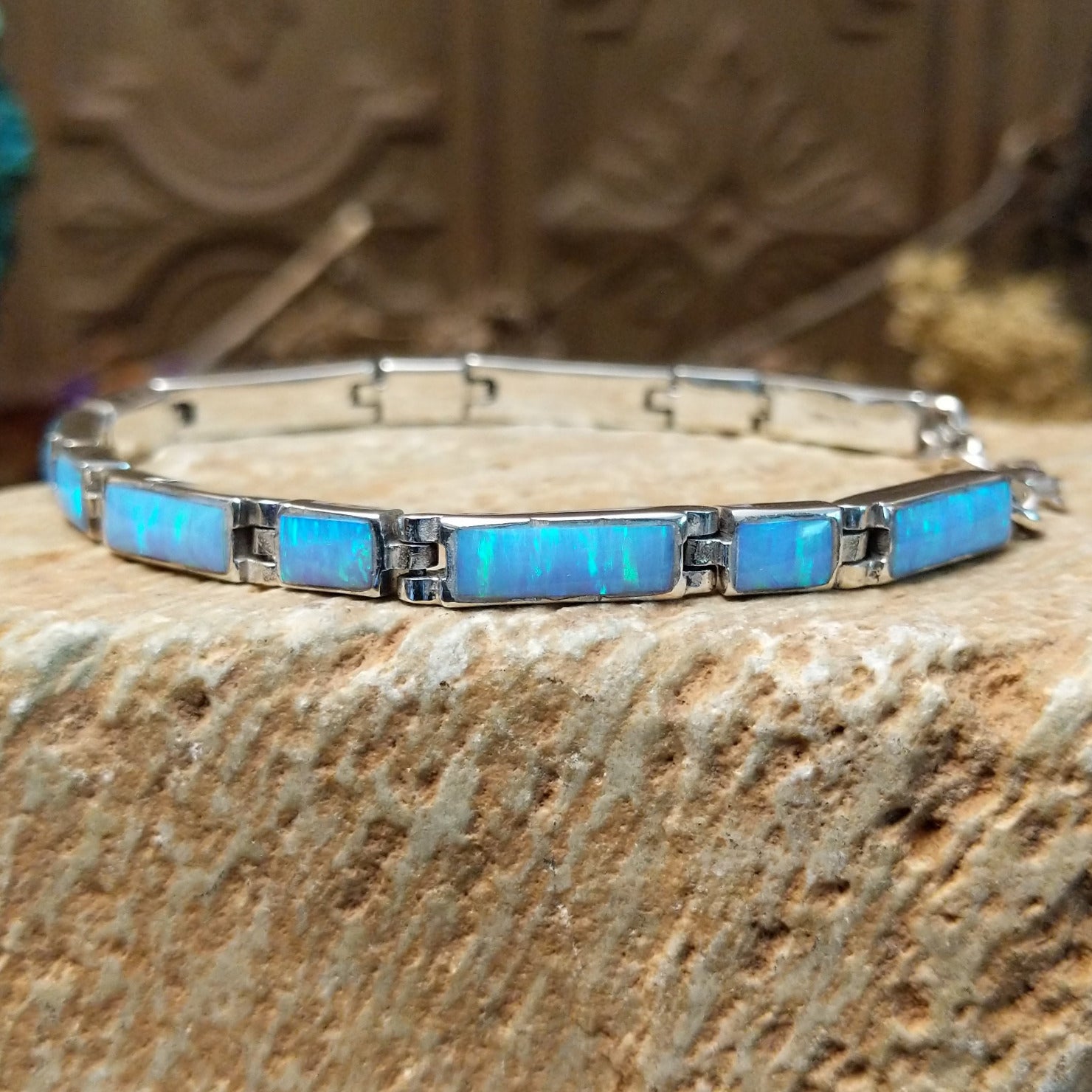 Sterling silver link bracelet with blue, manmade opal set in rectangular bezels.