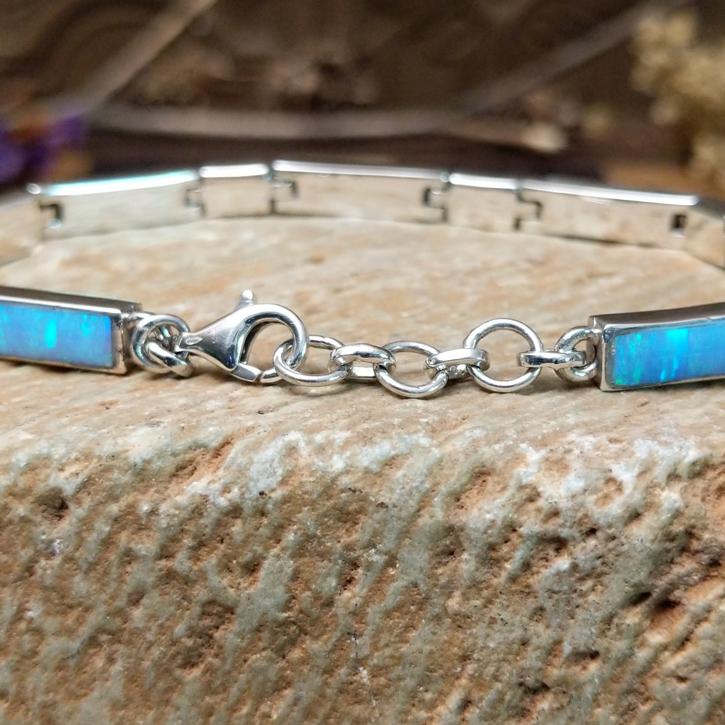 Sterling silver link bracelet with blue, manmade opal set in rectangular bezels.