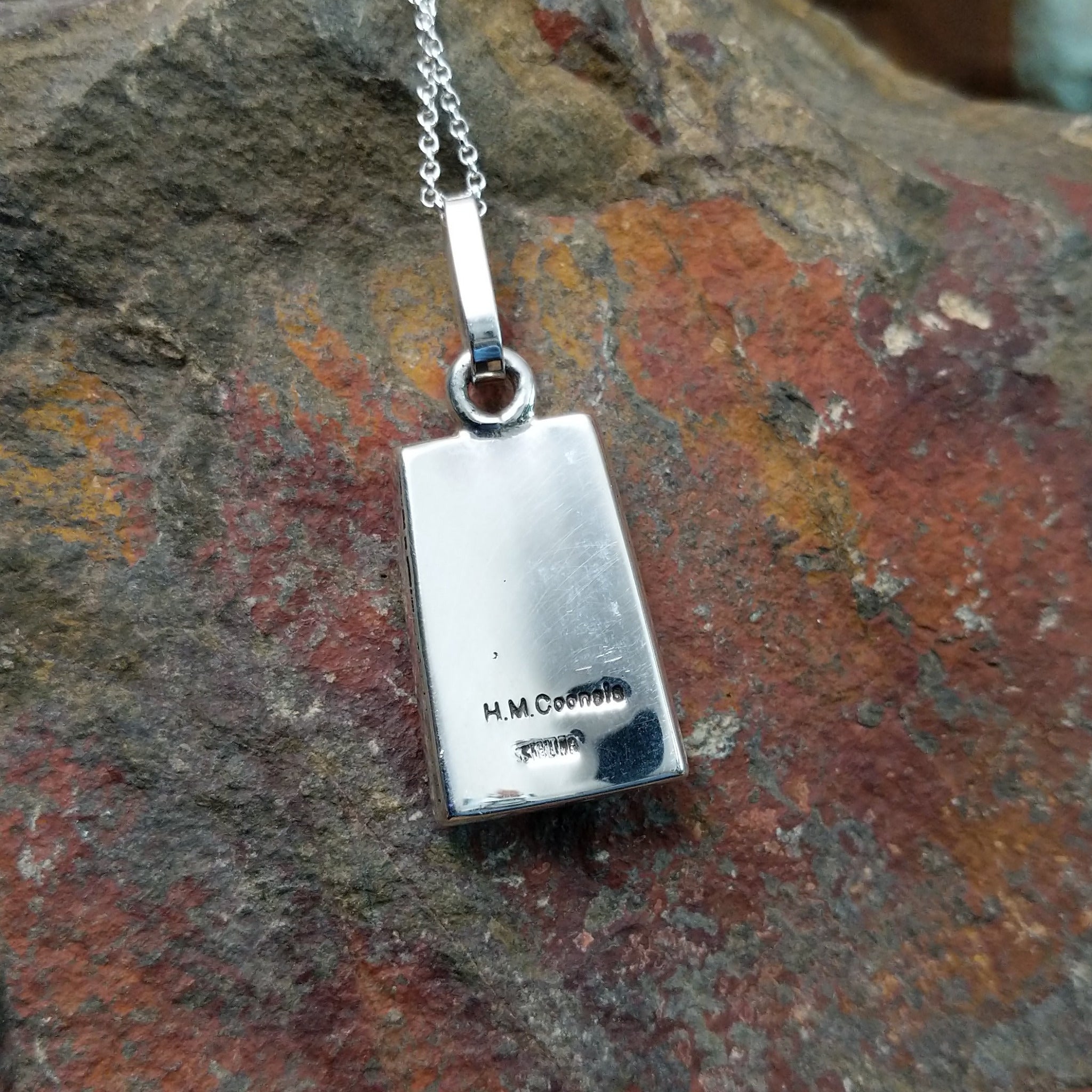 Handcrafted sterling silver turquoise and black onyx inlay pendant by Harlan & Monica Coonsis, featuring a rectangular geometric design; artisan and Sterling Silver stamp.