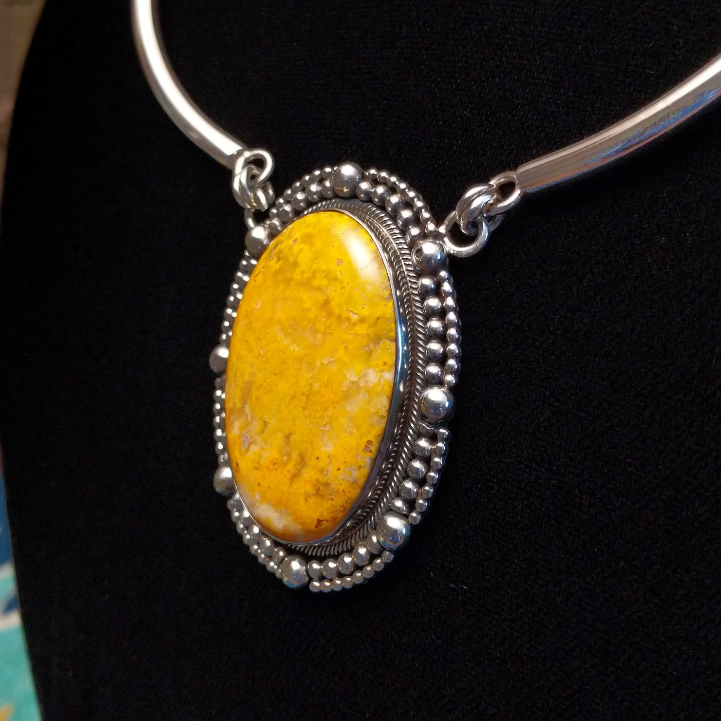 Bumblebee jasper stone set in a dotted bezel with a sterling silver linked collar.