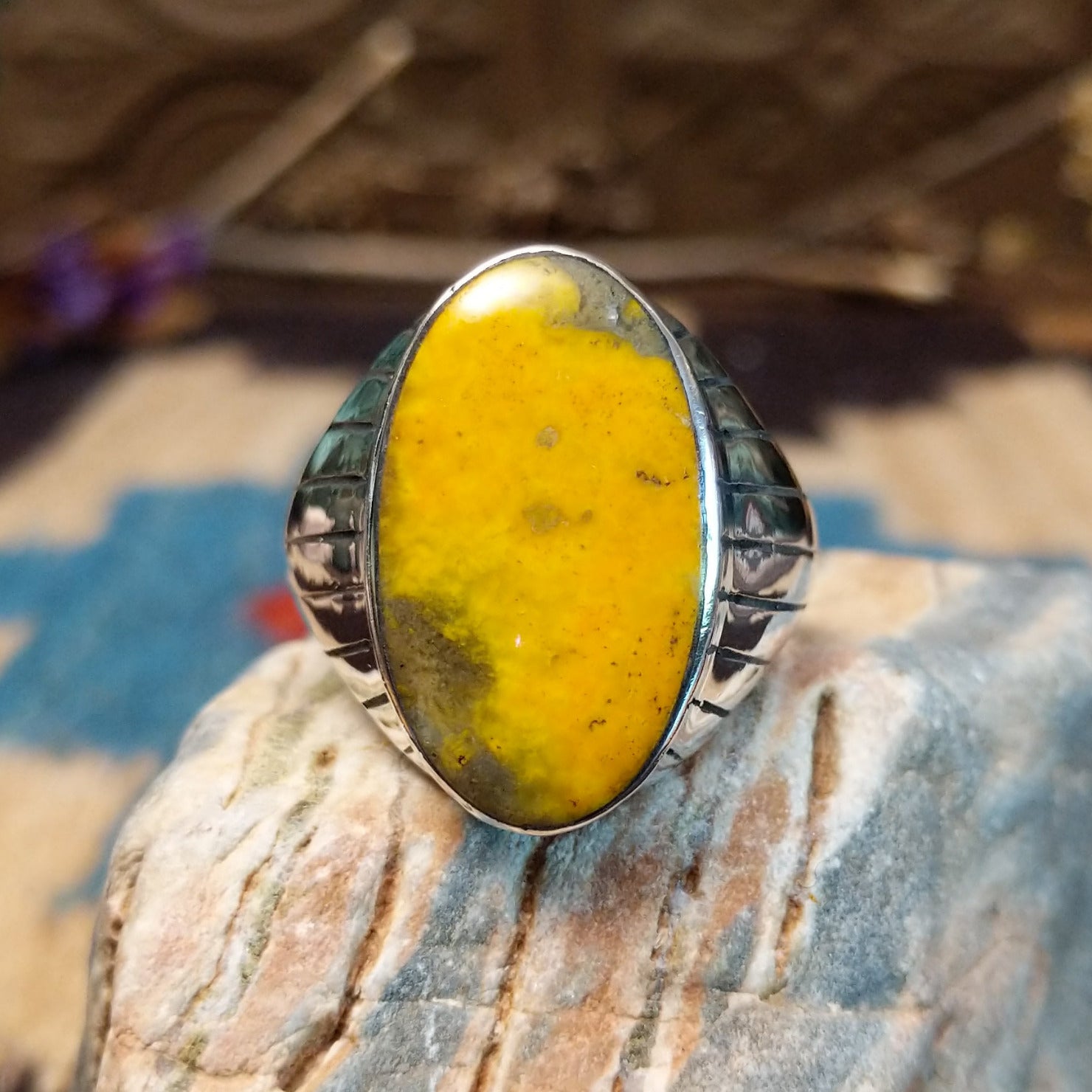 Sterling silver ring with bumblebee jasper set in an oval bezel and ornate stamping on the band.