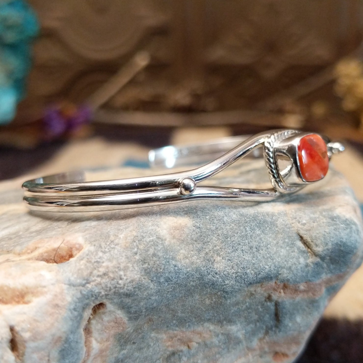 Sterling silver cuff bracelet with red spiny oyster shell set in a rounded-square bezel, framed by twisted rope accents.