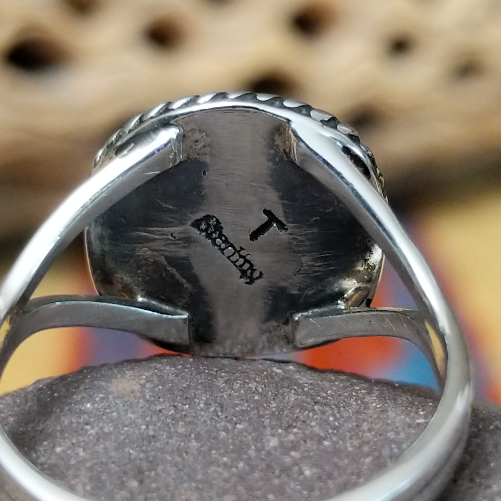 Charoite ring by Terry Wood, featuring a vibrant purple charoite stone with natural swirling patterns set in a handcrafted sterling silver band. Artisan and Sterling Silver stamp.