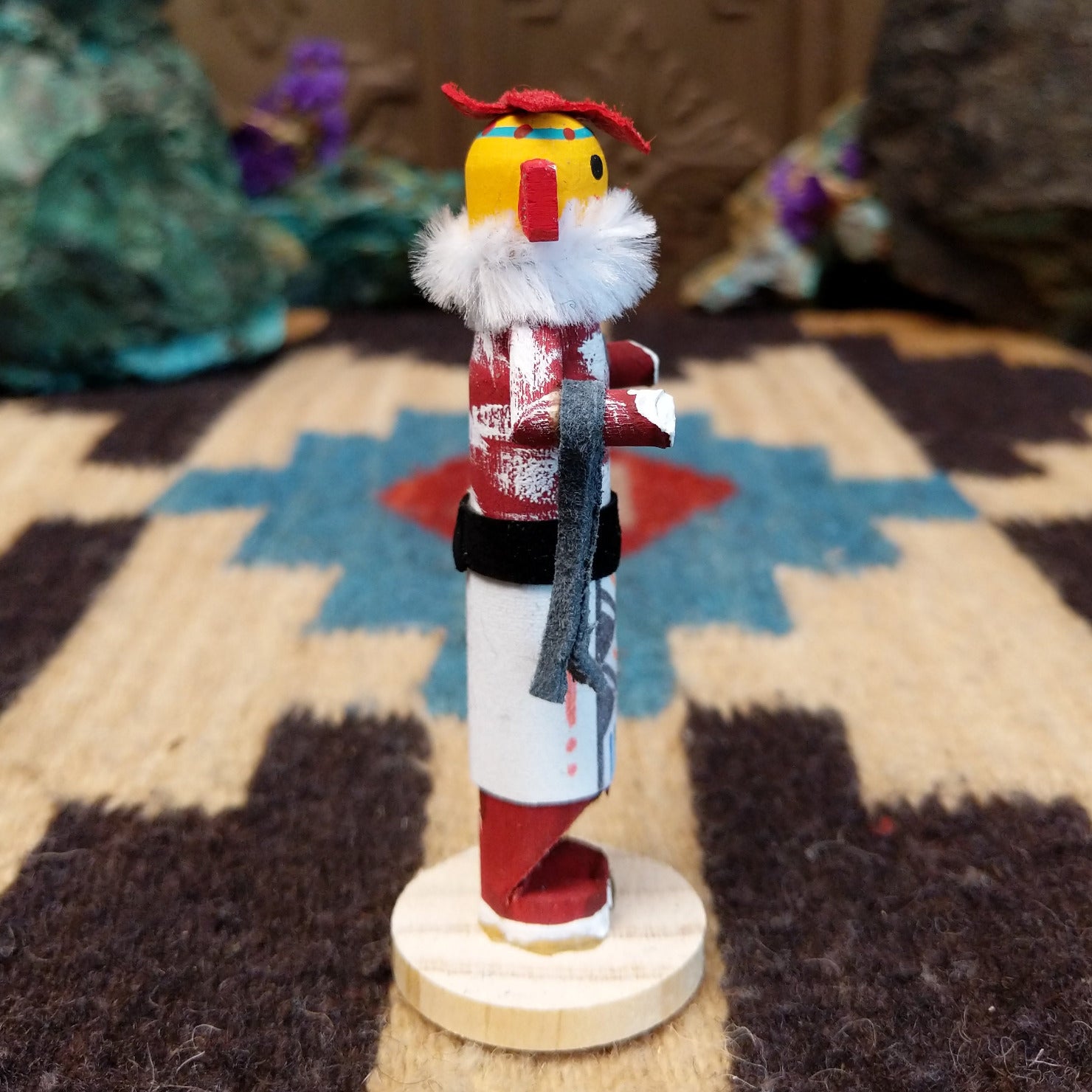 Mini chili pepper kachina by Rosalind Grey with yellow face, white fur collar, red body, and white geometric-patterned garment.