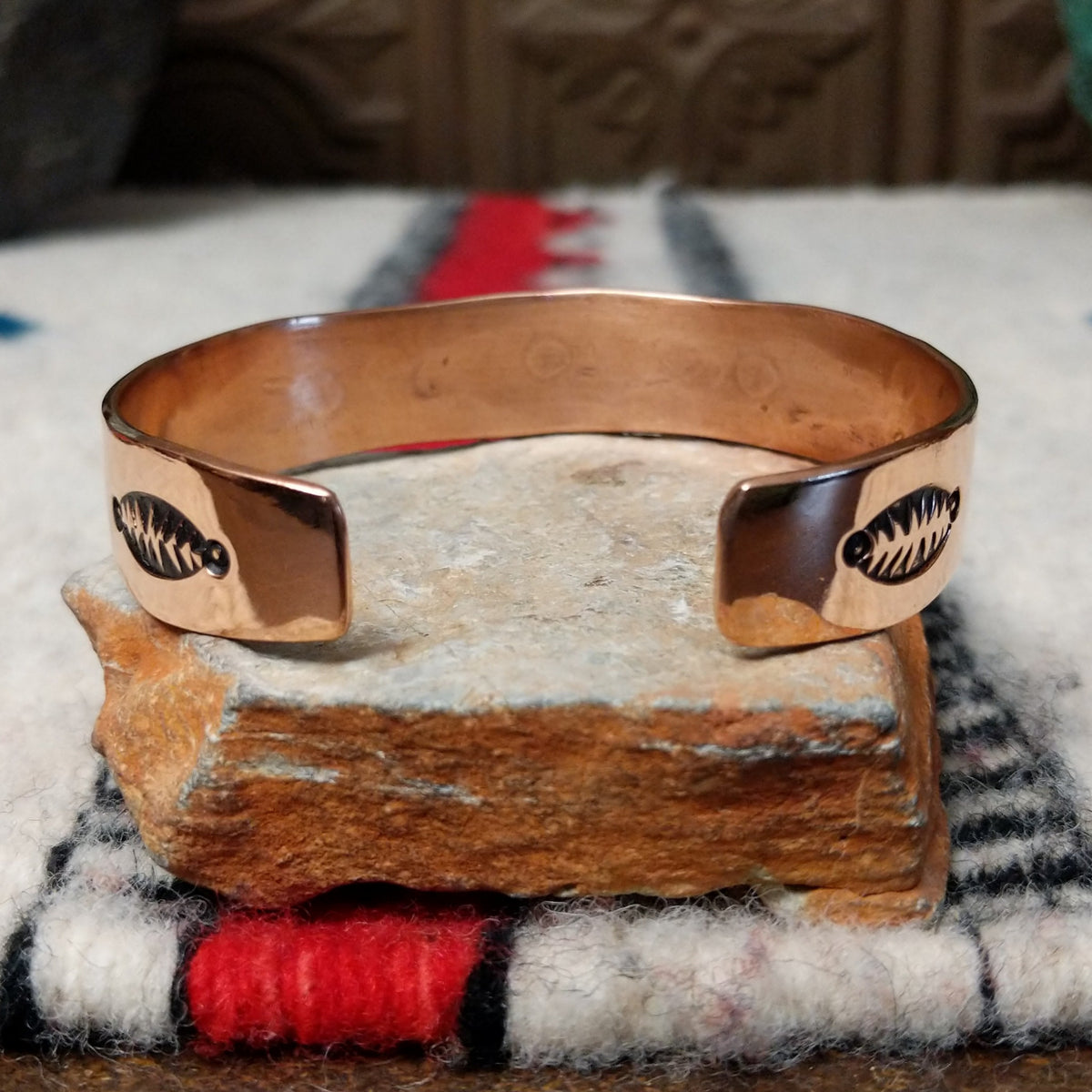 This Copper & Silver Feather Cuff by Robert Little features polished copper borders and a sterling silver center decorated with detailed feather motifs, curved accents, and dark oxidized stamping; underside view.
