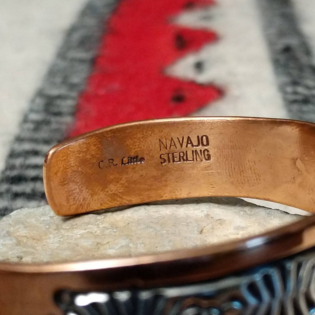 Copper and silver cuff by Robert Little featuring an intricate repeating hand-stamped geometric pattern with oxidized accents, framed by polished copper borders; artisan and Sterling Silver stamp.
