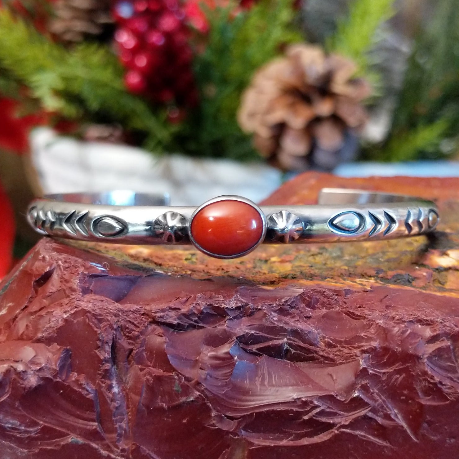 Sterling silver cuff with stamped designs and petite oval coral set in the bezel.