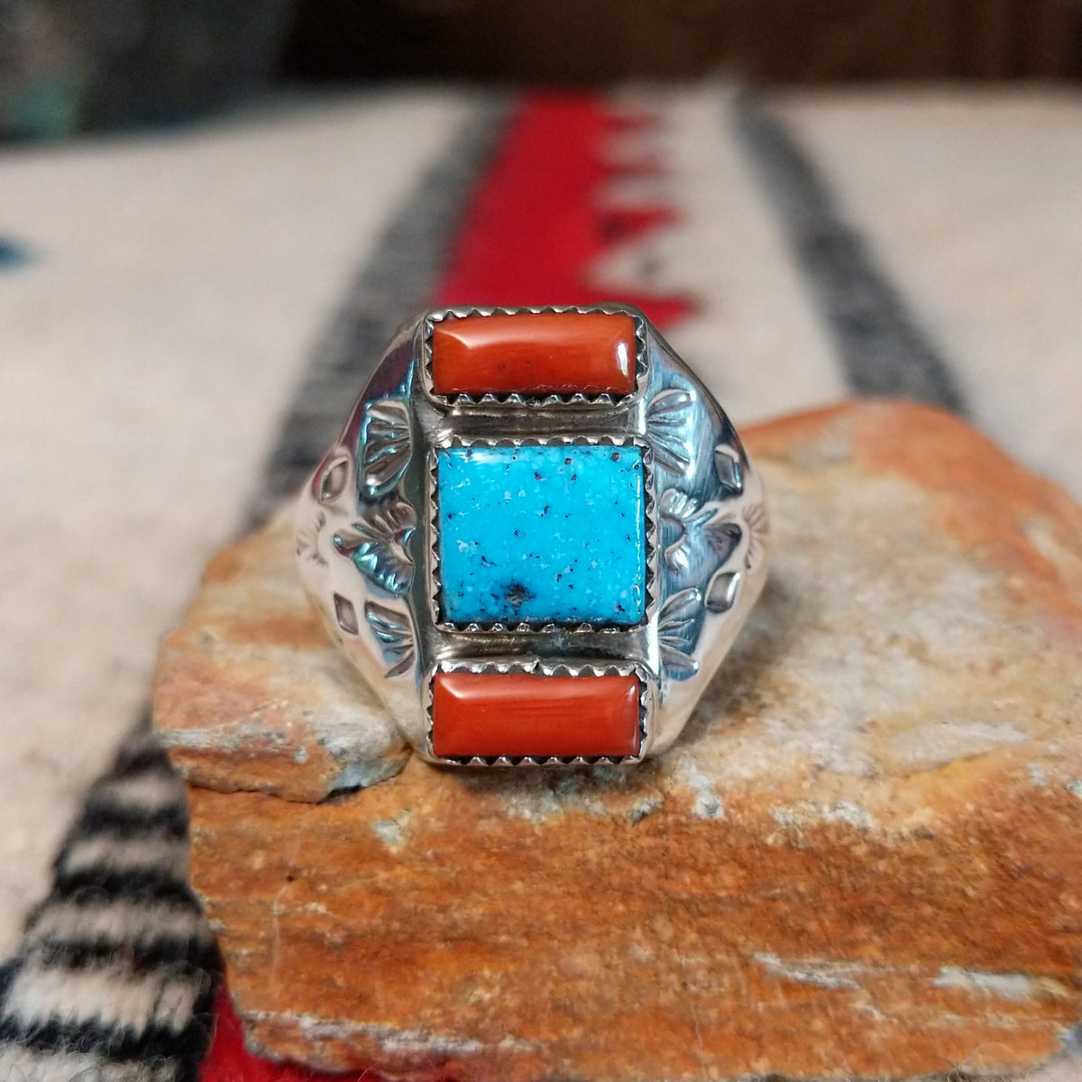 Coral and turquoise silver ring by Pauline Nelson with stamped motifs.