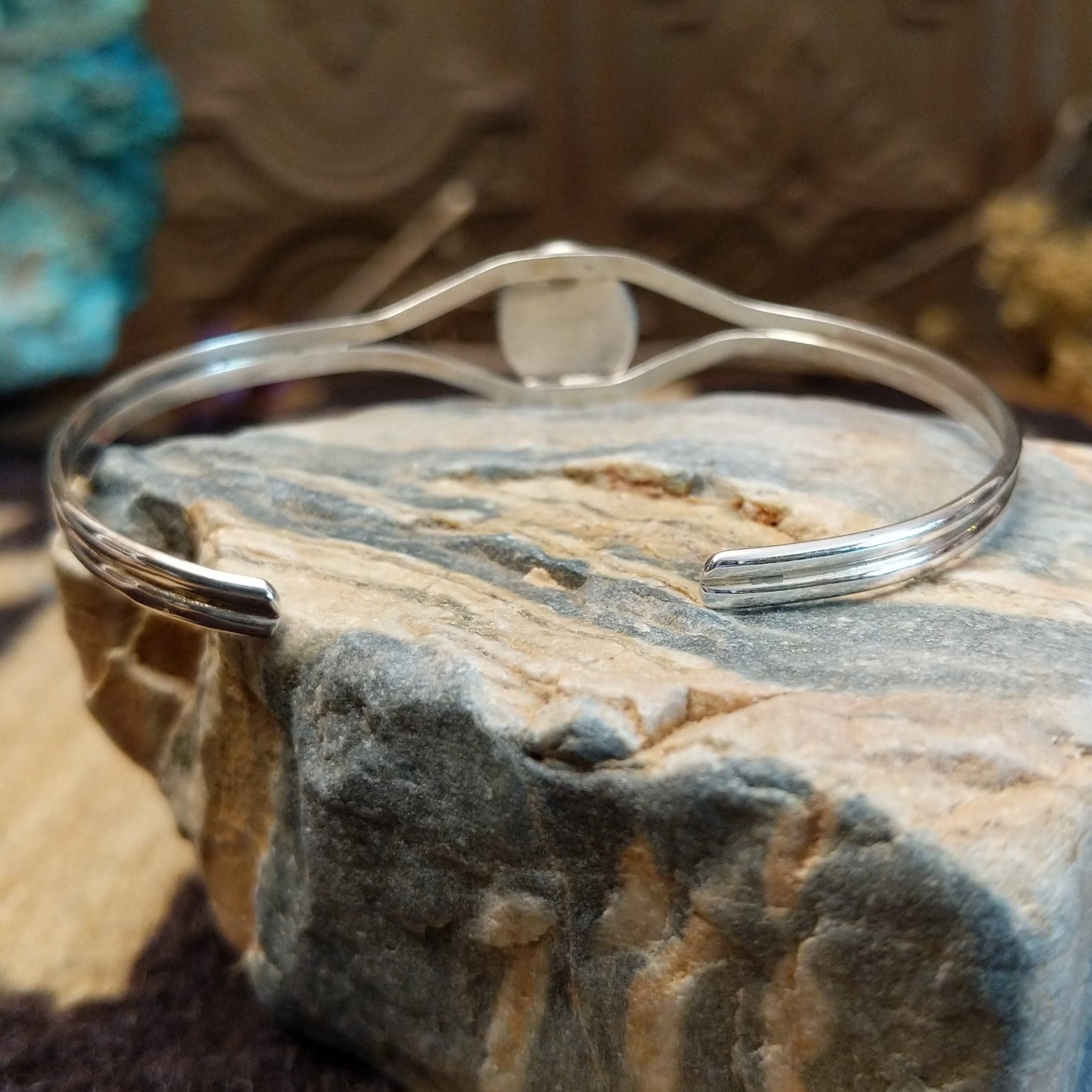 Sterling silver cuff with Boulder turquoise set in a round bezel, framed by twisted rope and silverwork band.