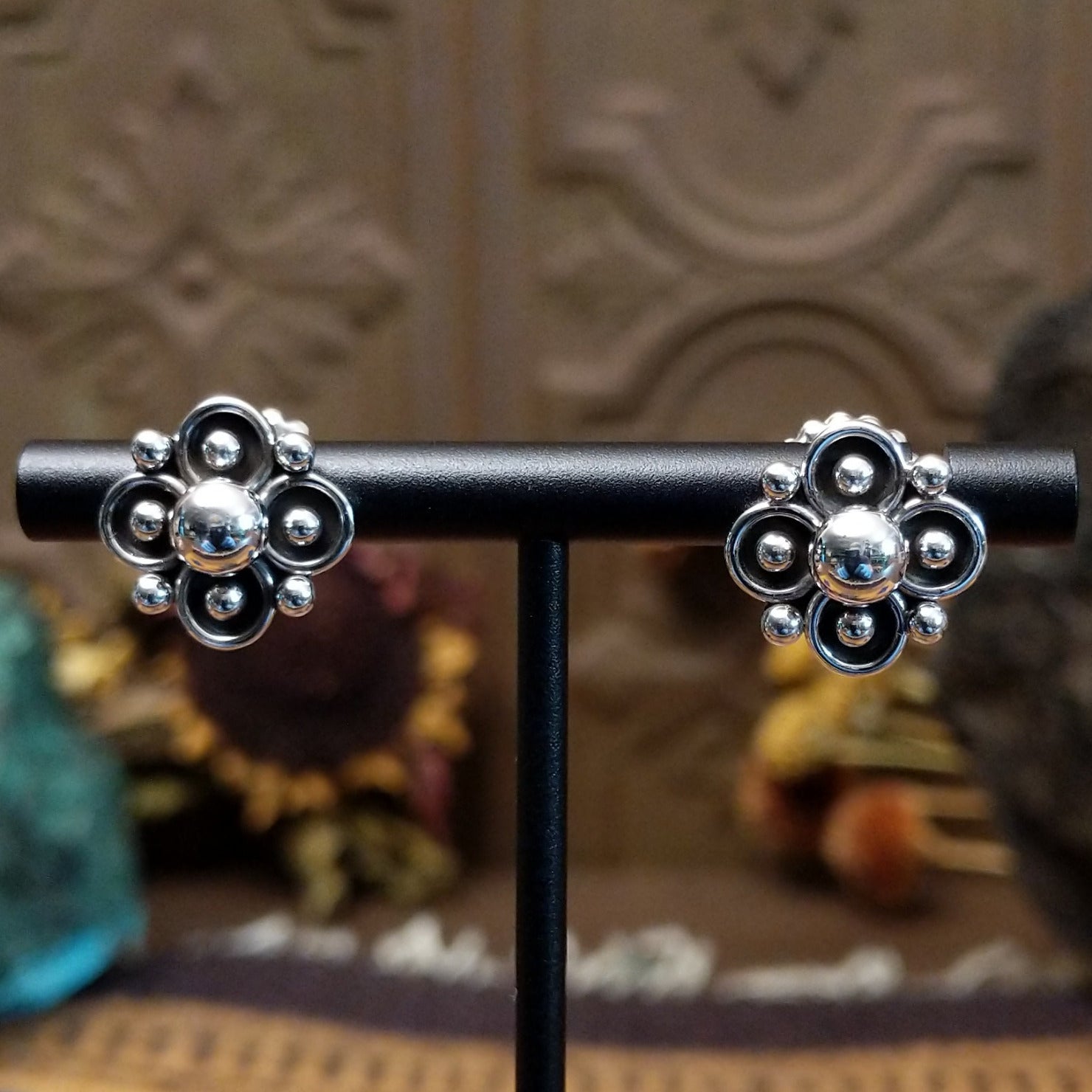 Sterling silver floral stud earrings by Navajo artist Artie Yellowhorse featuring polished silver beadwork and oxidized flower details.