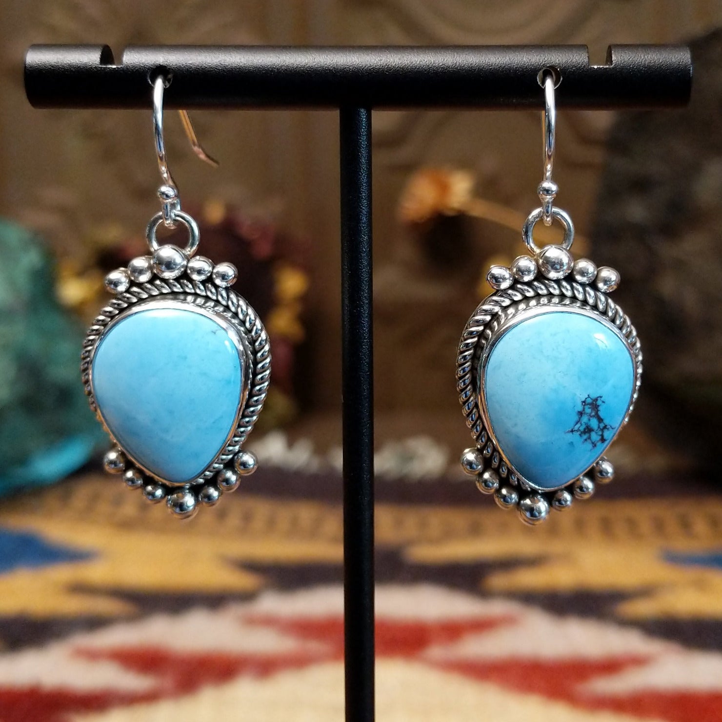 Sterling silver Golden Hills turquoise dangle earrings featuring teardrop-shaped stones, rope detailing, and silver bead accents.