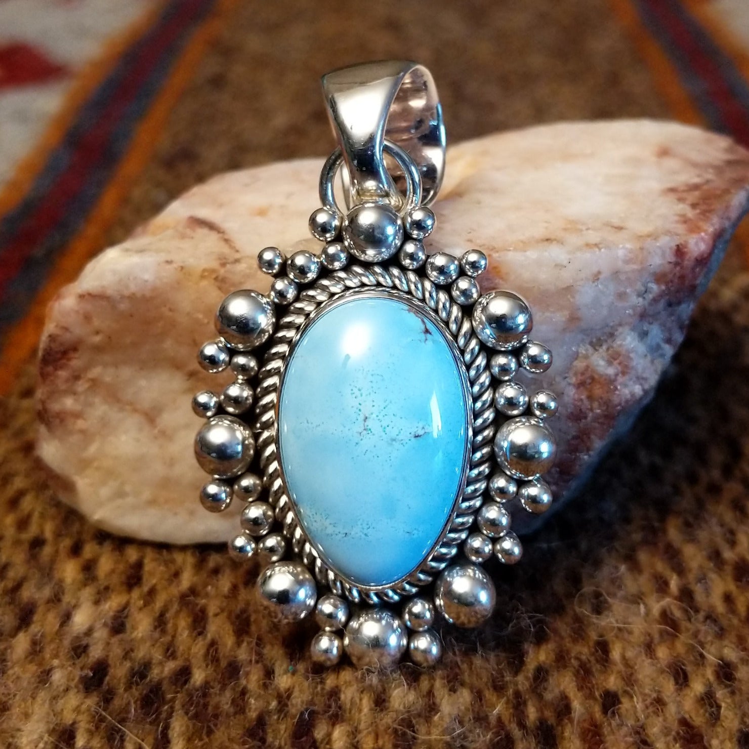 Round sterling silver pendant with golden hills turquoise set in the bezel, framed by twisted rope and dotted accents.