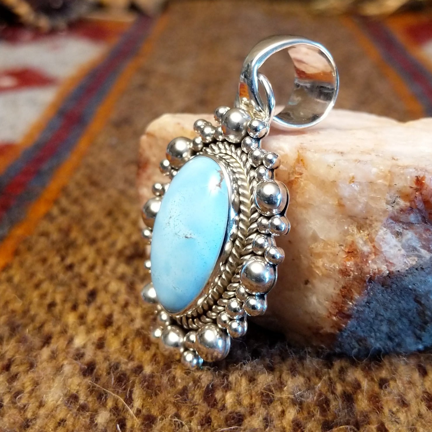 Round sterling silver pendant with golden hills turquoise set in the bezel, framed by twisted rope and dotted accents.