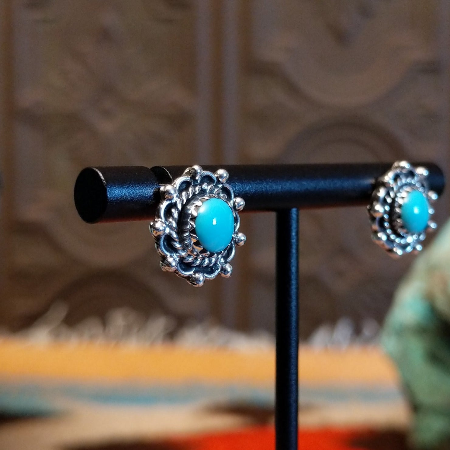 Sterling silver earrings with Kingman turquoise set in round bezels, framed by twisted rope and dotted accents.