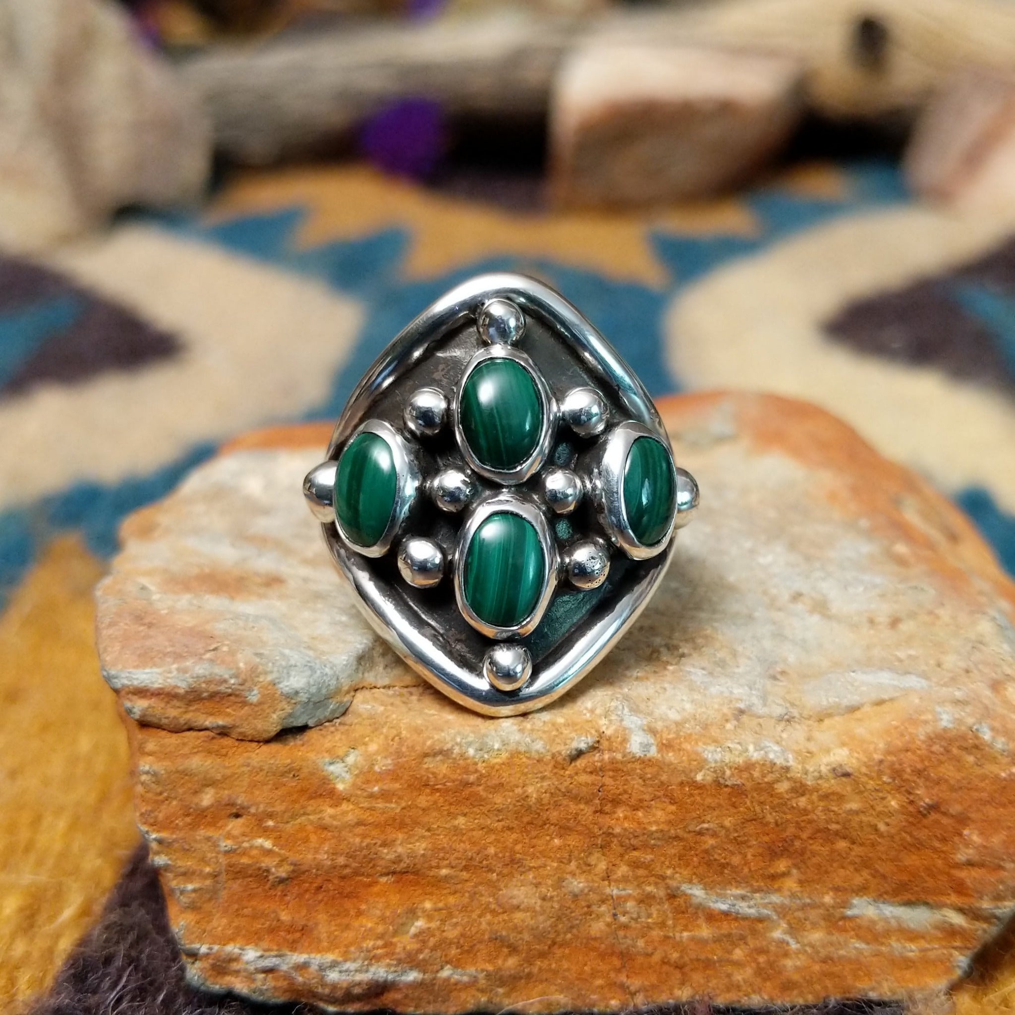 Sterling silver Malachite ring by Raymond Coriz featuring four oval green stones with natural banding.