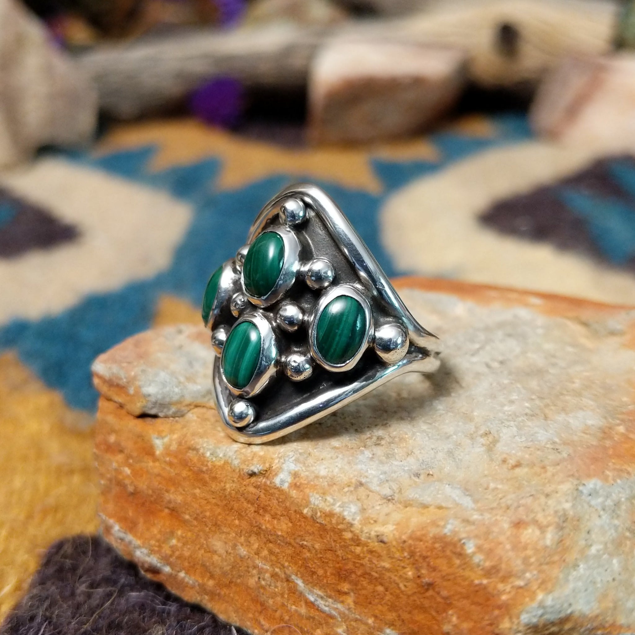 Sterling silver Malachite ring by Raymond Coriz featuring four oval green stones with natural banding; side view.
