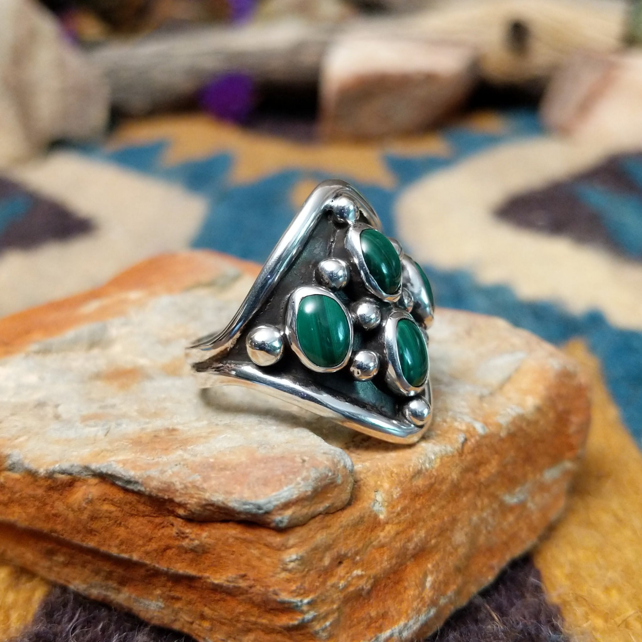 Sterling silver Malachite ring by Raymond Coriz featuring four oval green stones with natural banding; side view.