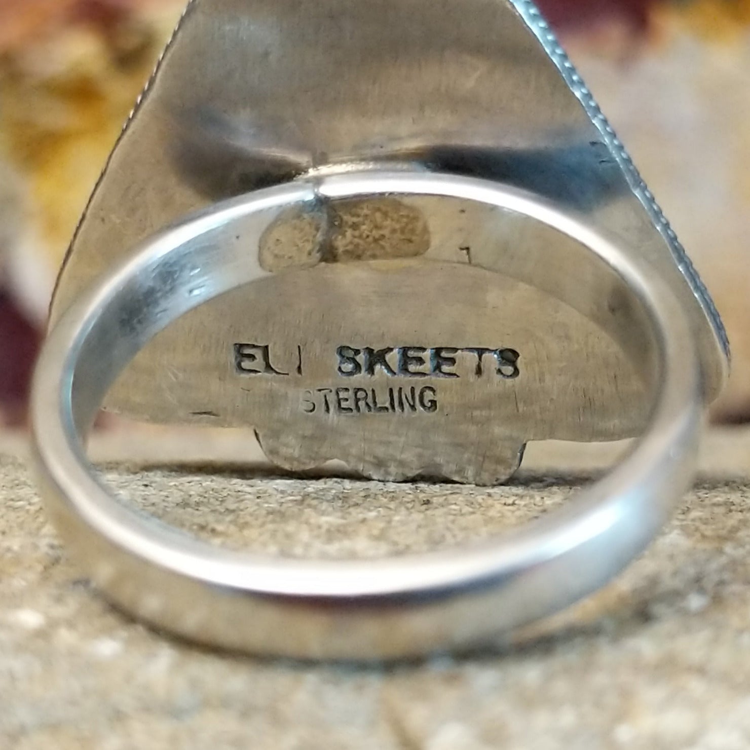 The artisan's stamp found on the underside of the bezel.