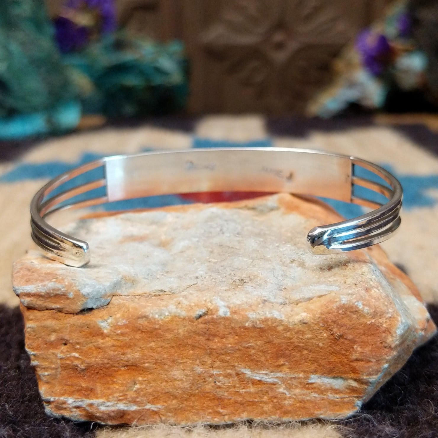 Dual row manmade opal inlay cuff by Jamie Johnson, featuring shimmering opal inlay with vibrant flashes of color set in handcrafted Southwestern-inspired metalwork. Underside view.