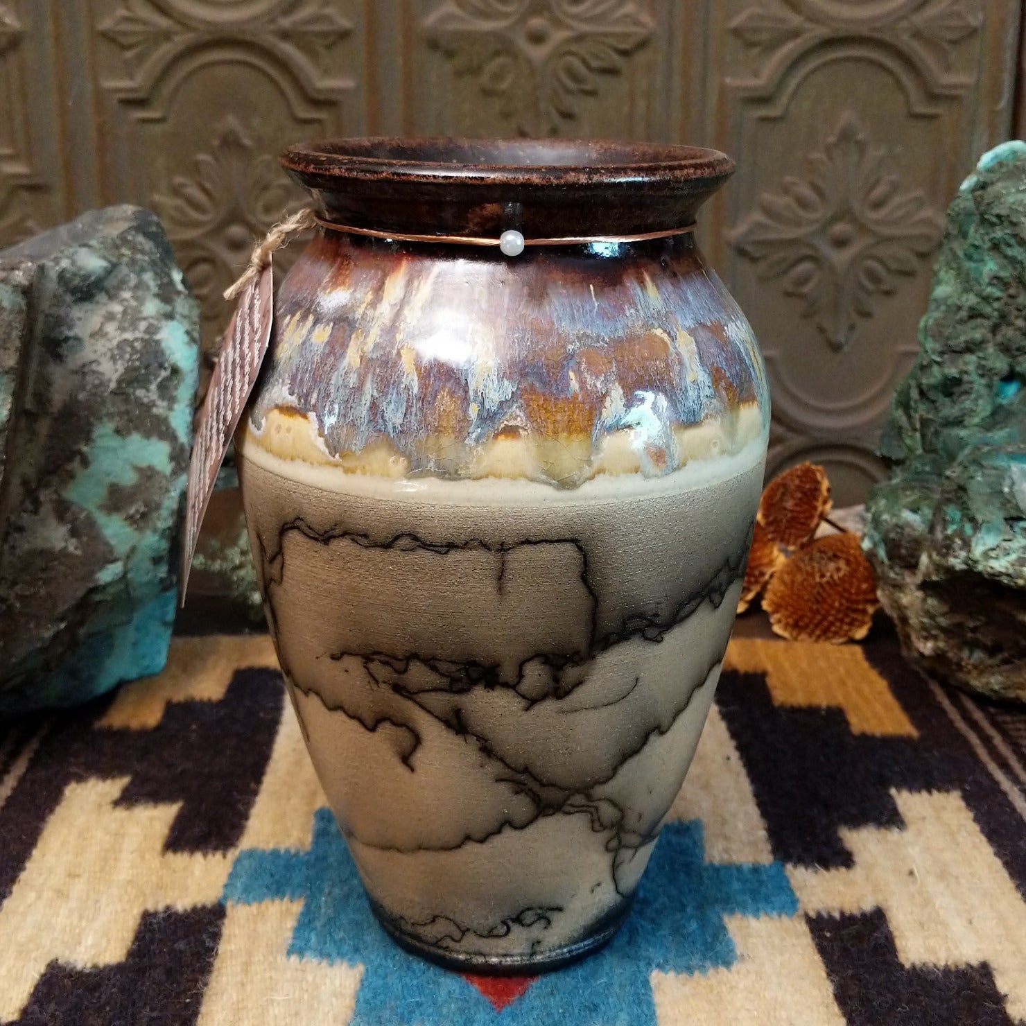 Ceramic, horsehair, and copper pottery piece.