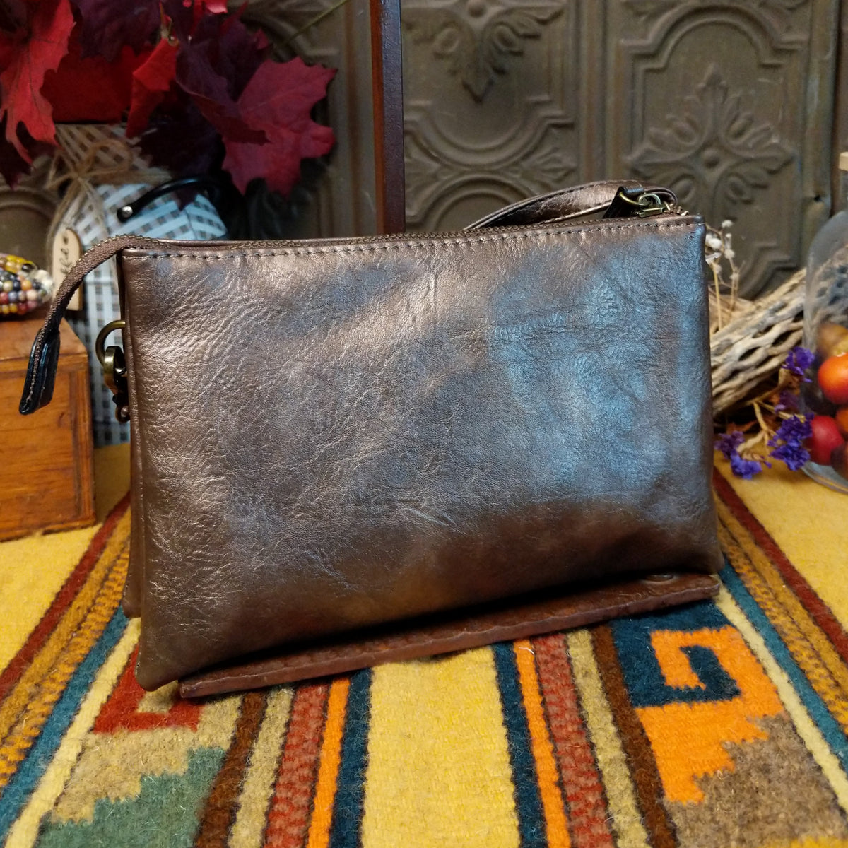 Ella Handbag by Liz Soto featuring a compact structured silhouette, textured exterior, dual handles, turn-lock accent, top zip closure, and rectangular Liz Soto logo plaque; back view.