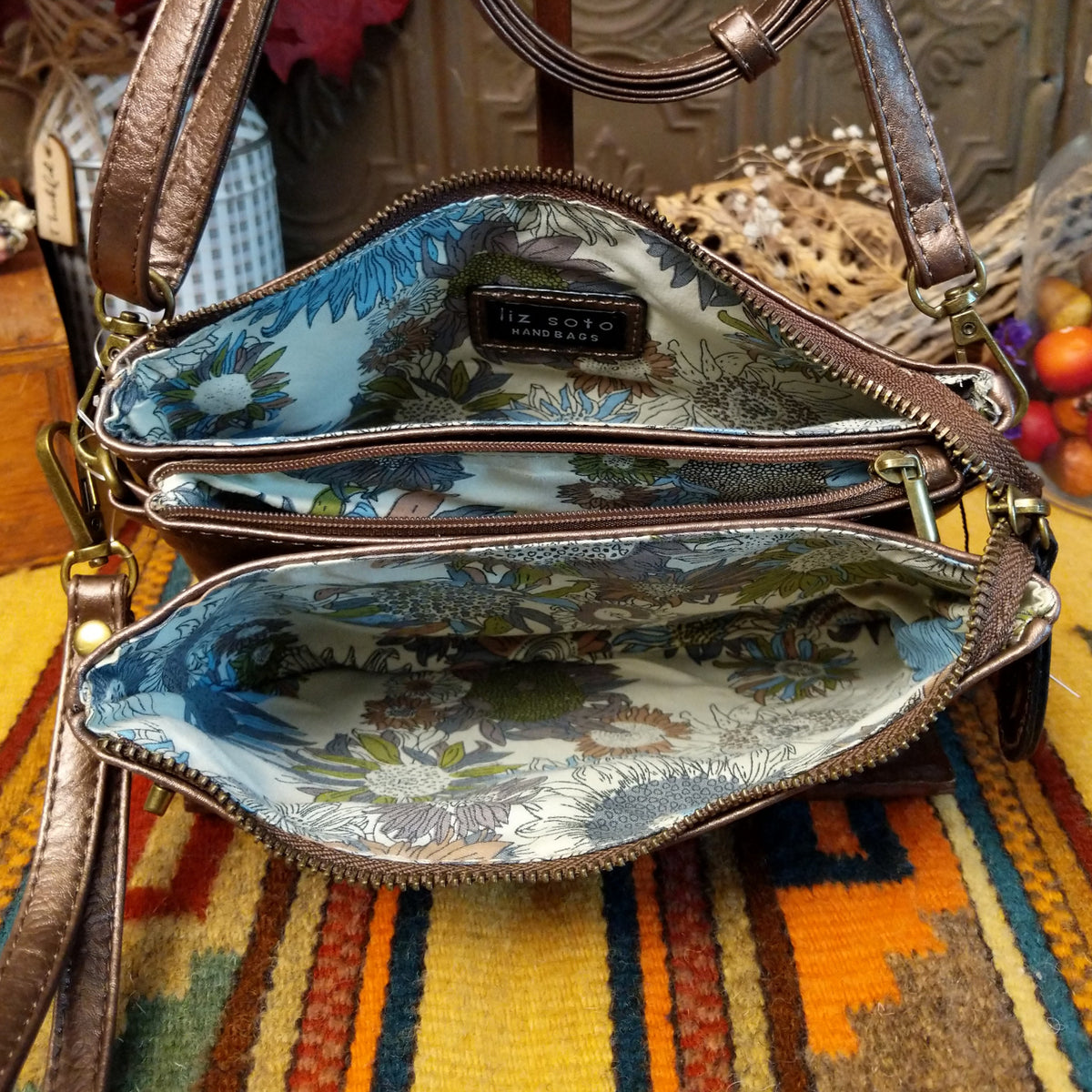 Ella Handbag by Liz Soto featuring a compact structured silhouette, textured exterior, dual handles, turn-lock accent, top zip closure, and rectangular Liz Soto logo plaque; interior view.