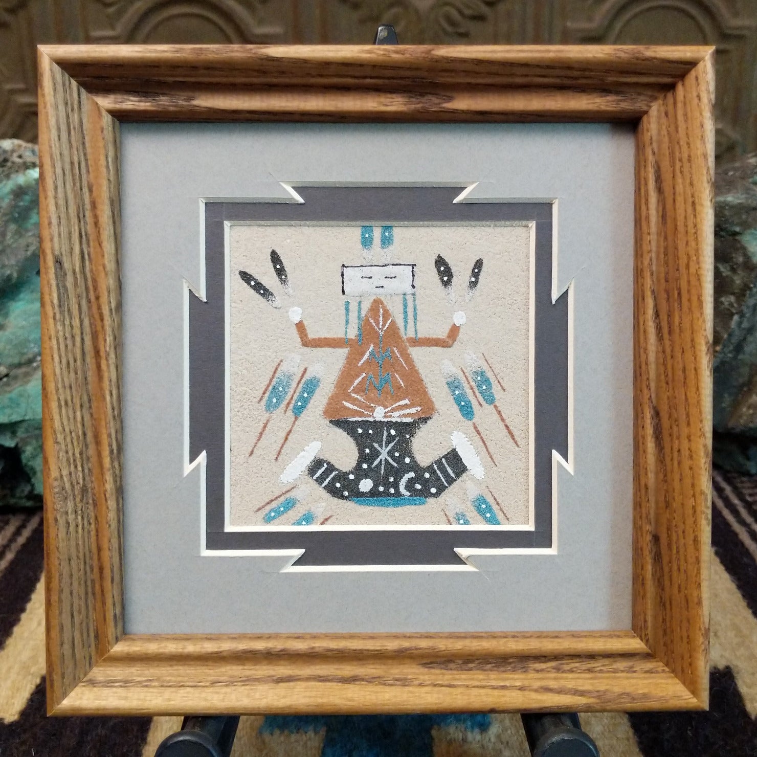 Framed Navajo sand painting of Father Sky with symbolic motifs.