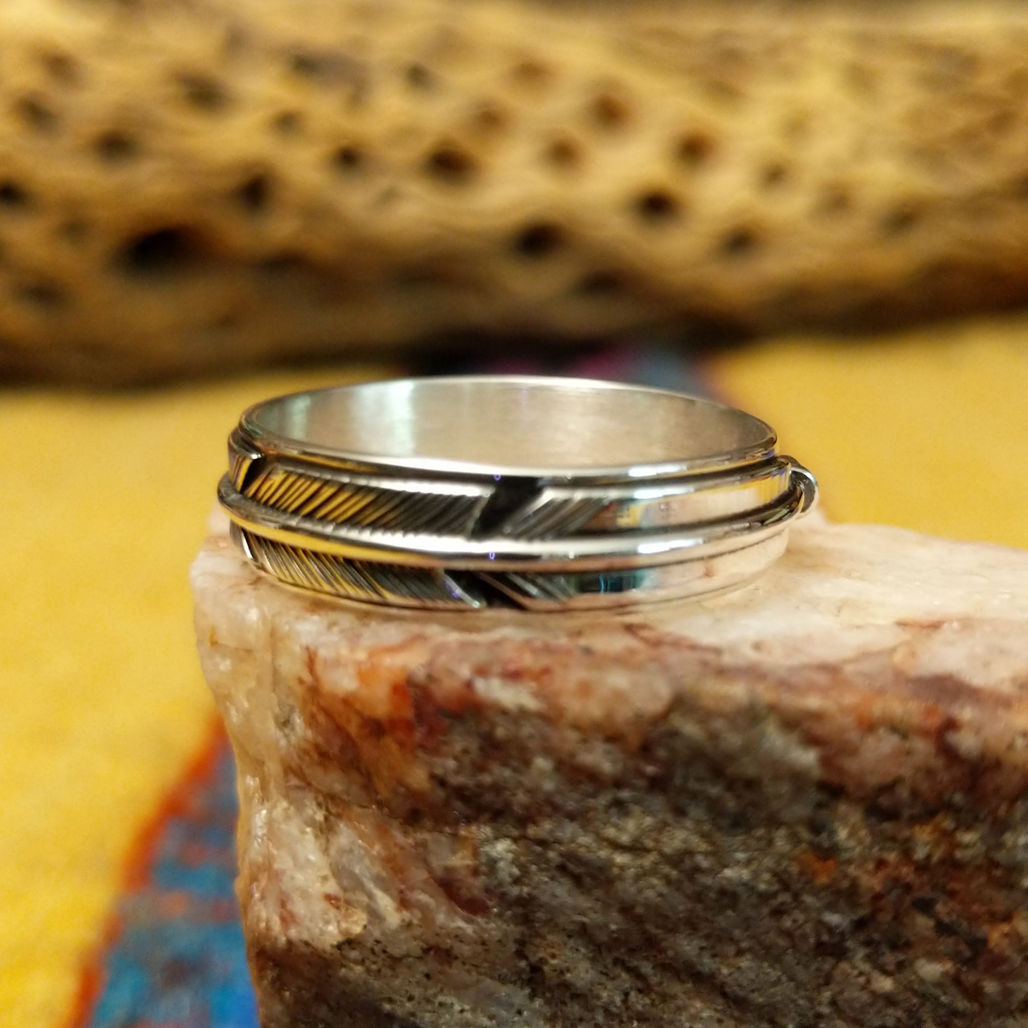 Feather loop ring by Raymond Coriz, featuring a detailed handcrafted feather design wrapped around a polished sterling silver band with traditional Southwestern-inspired craftsmanship.