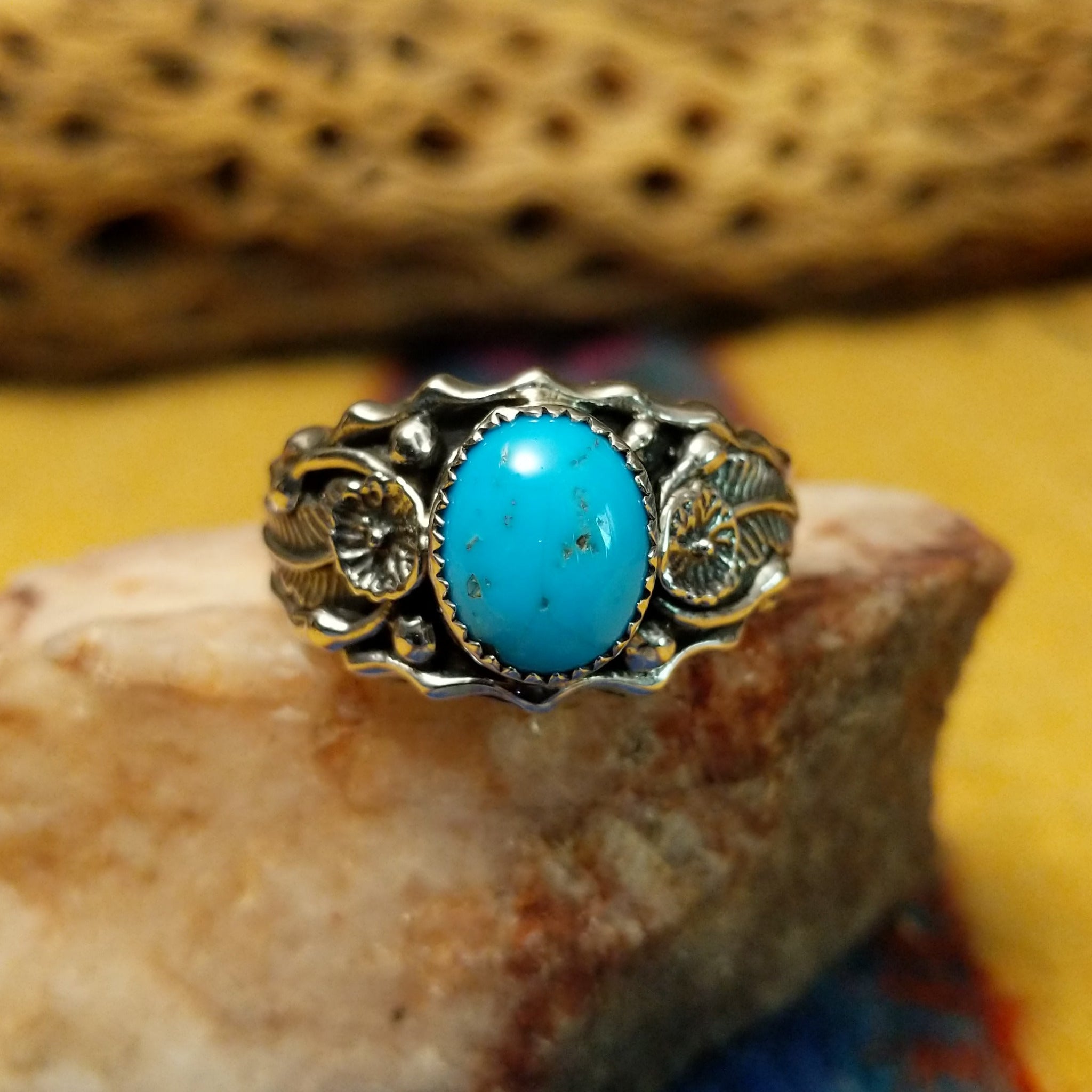 Turquoise ring with detailed sterling silver band by Raymond Coriz, featuring a vibrant blue turquoise stone with natural matrix set in a handcrafted sterling silver ring with intricate band detailing.