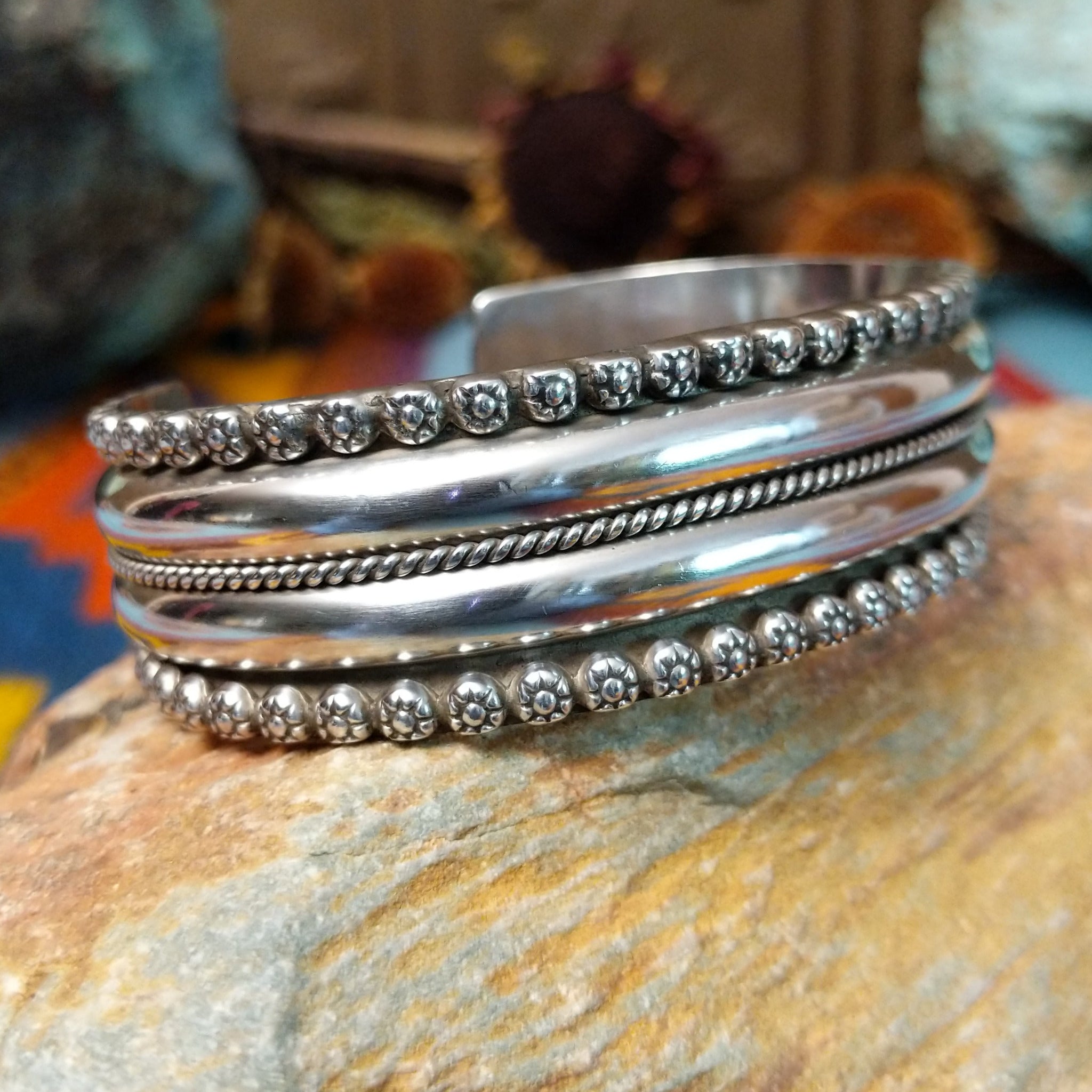 Wide silver cuff by Marc Antia with polished bands, twisted wire detail, and fluted silver borders.