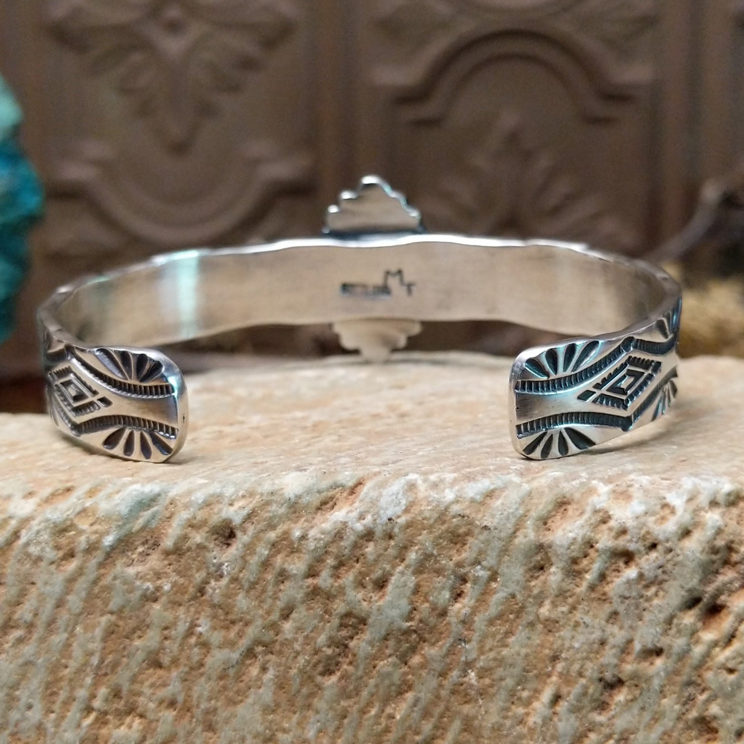 Sterling silver cuff bracelet with black onyx set in the oval bezel, framed by twisted rope and dotted accents while the band features abstract stamping.
