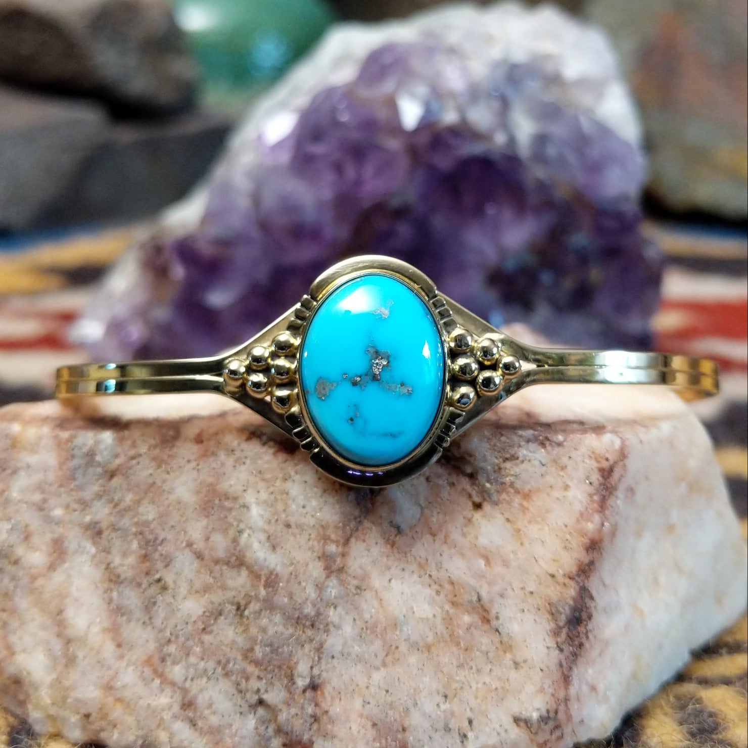14k gold cuff by Tom Lewis with oval turquoise stone and bead accents.