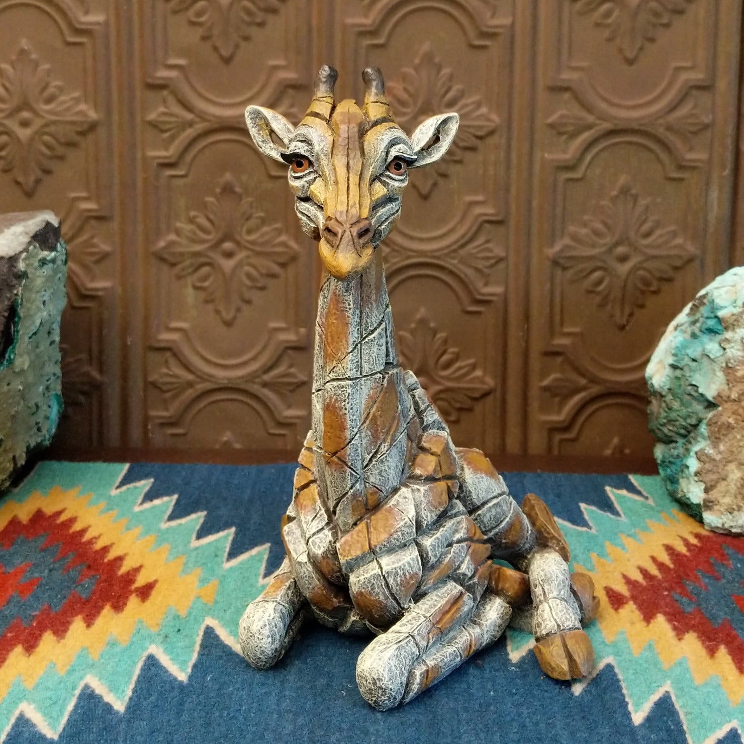 Cast marble of a giraffe calf painted in it's tradition orange and tan coloring.
