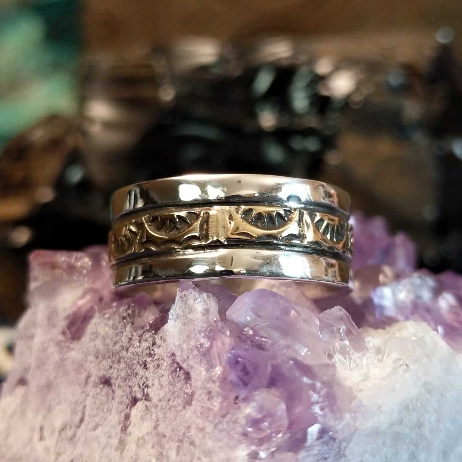 A sleek gold and silver ring featuring intricate designs.